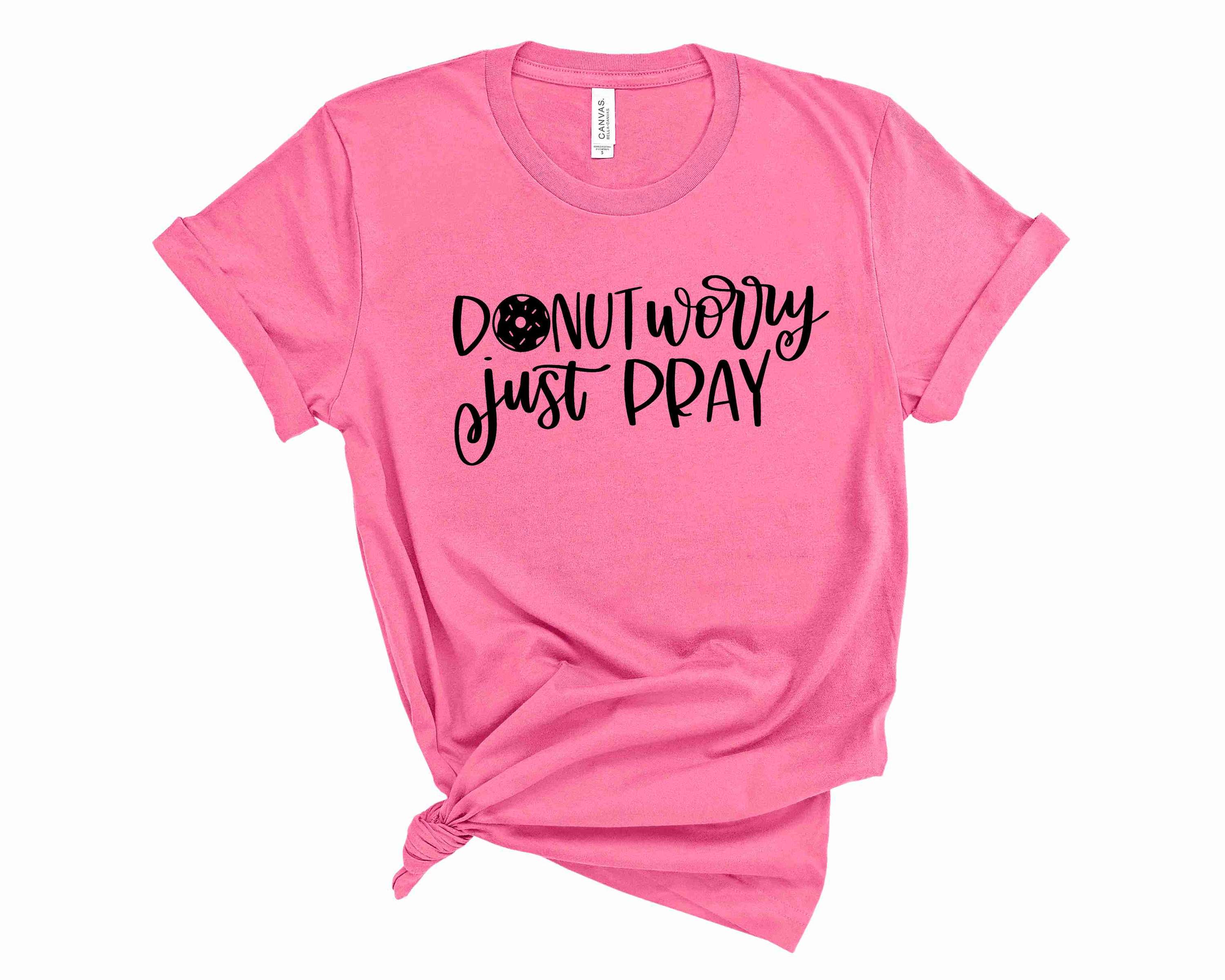 A unisex graphic tee featuring the phrase 'Donut Worry Just Pray' with a colorful donut illustration.