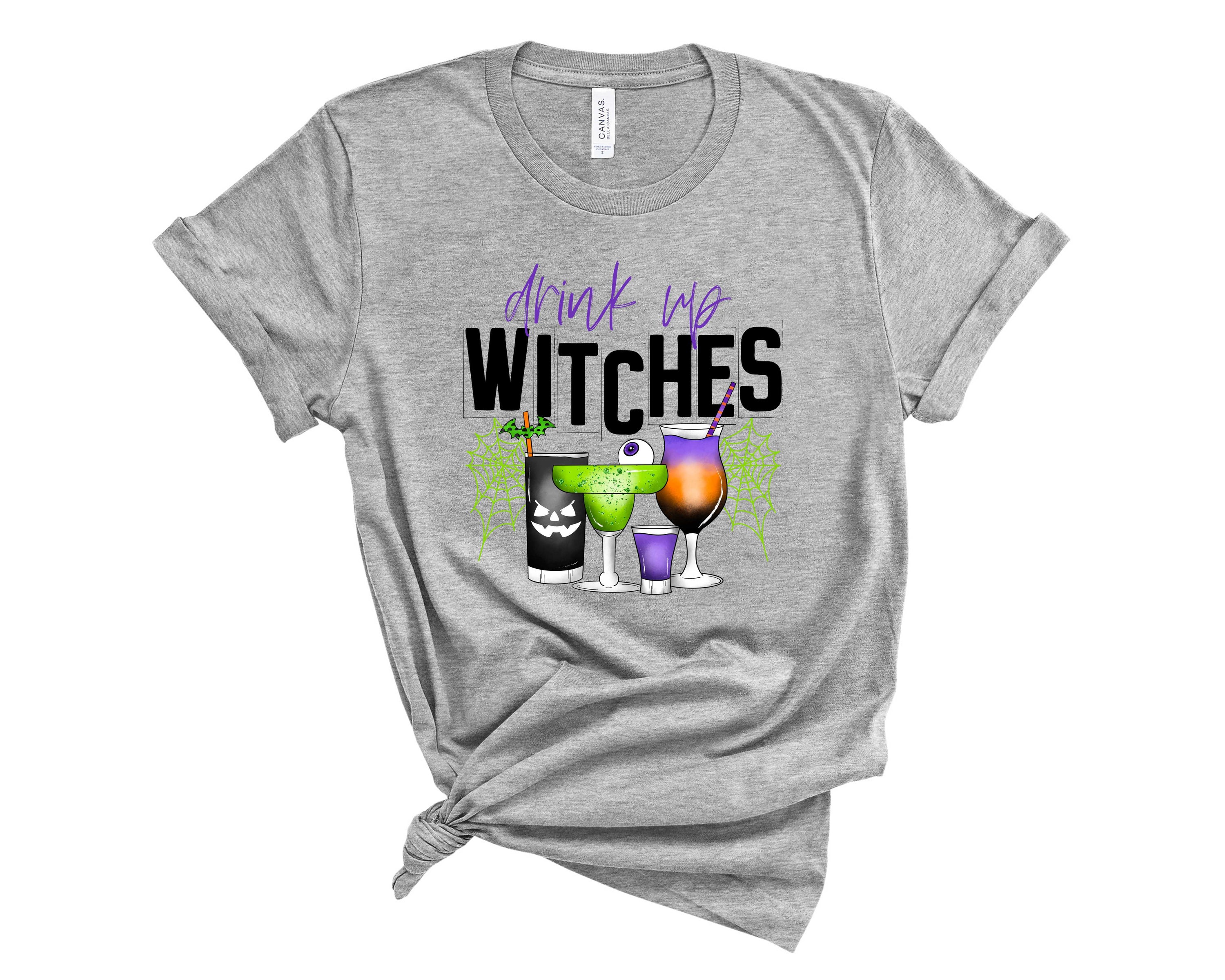 Drink Up Witches Green Graphic Tee featuring a vibrant green color and playful witch-themed graphic print.