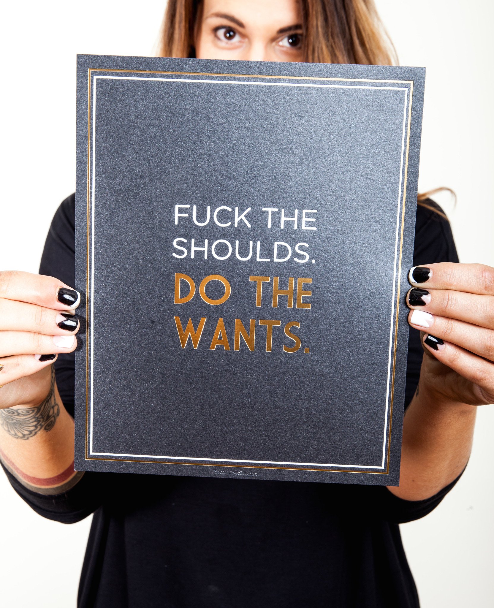 Art print featuring the phrase 'Fuck the Shoulds. Do the Wants.' in gold and white foil on metallic black paper, sized 8x10 inches.