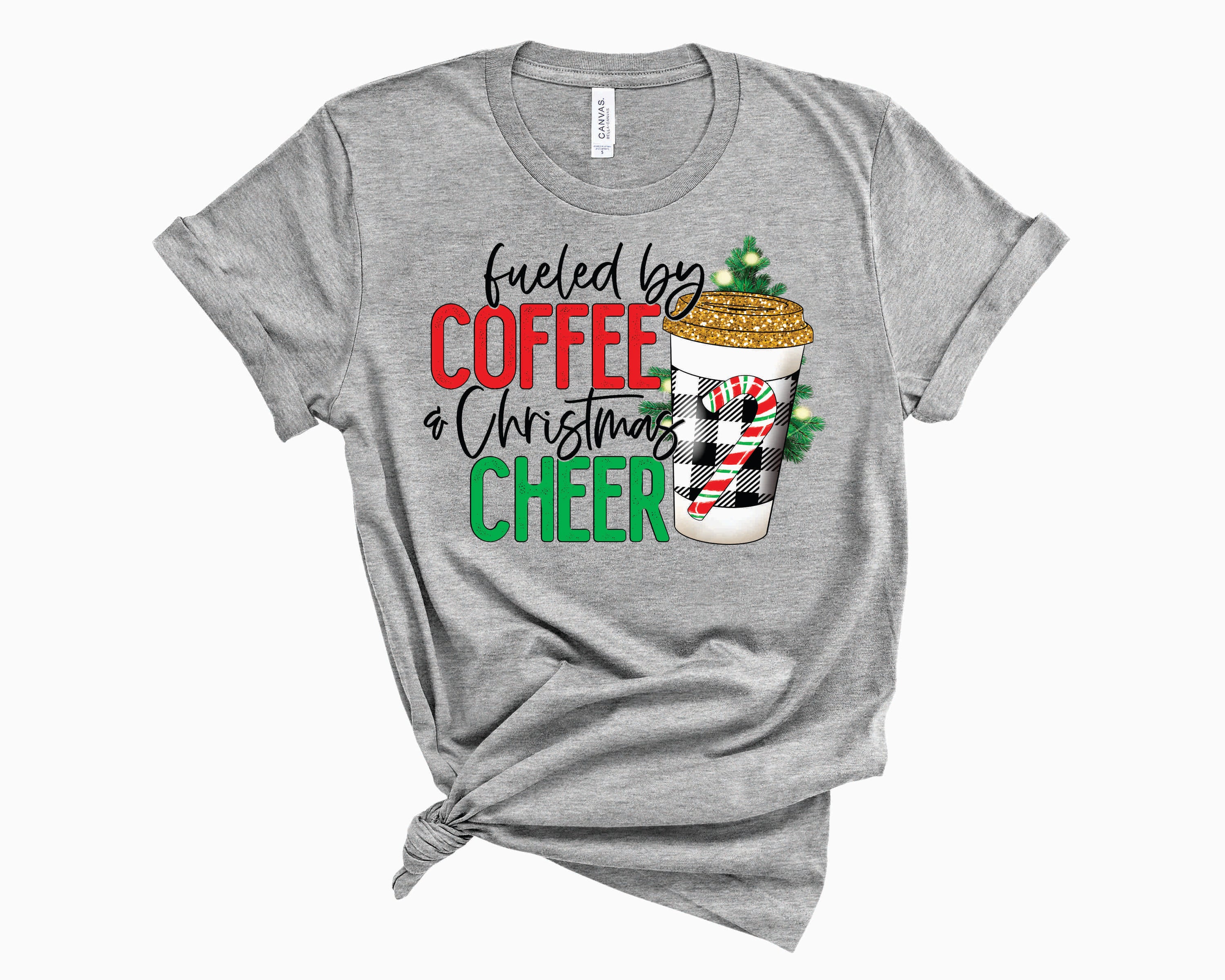 A unisex graphic tee featuring a festive plaid design with the text 'Fueled By Coffee & Christmas Cheer', perfect for holiday celebrations.