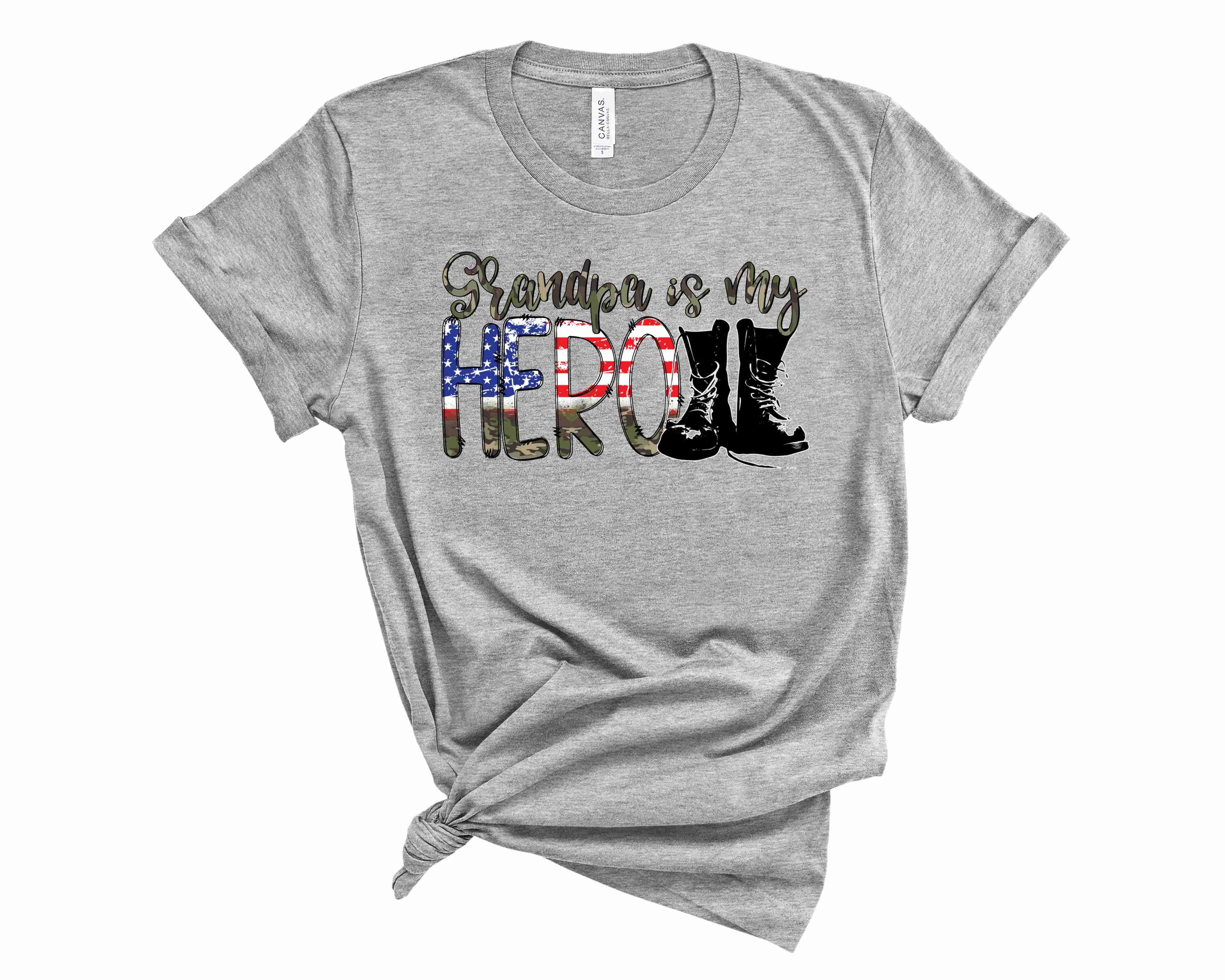 A stylish unisex camo graphic tee featuring the text 'Grandpa Is My HERO' in bold letters.