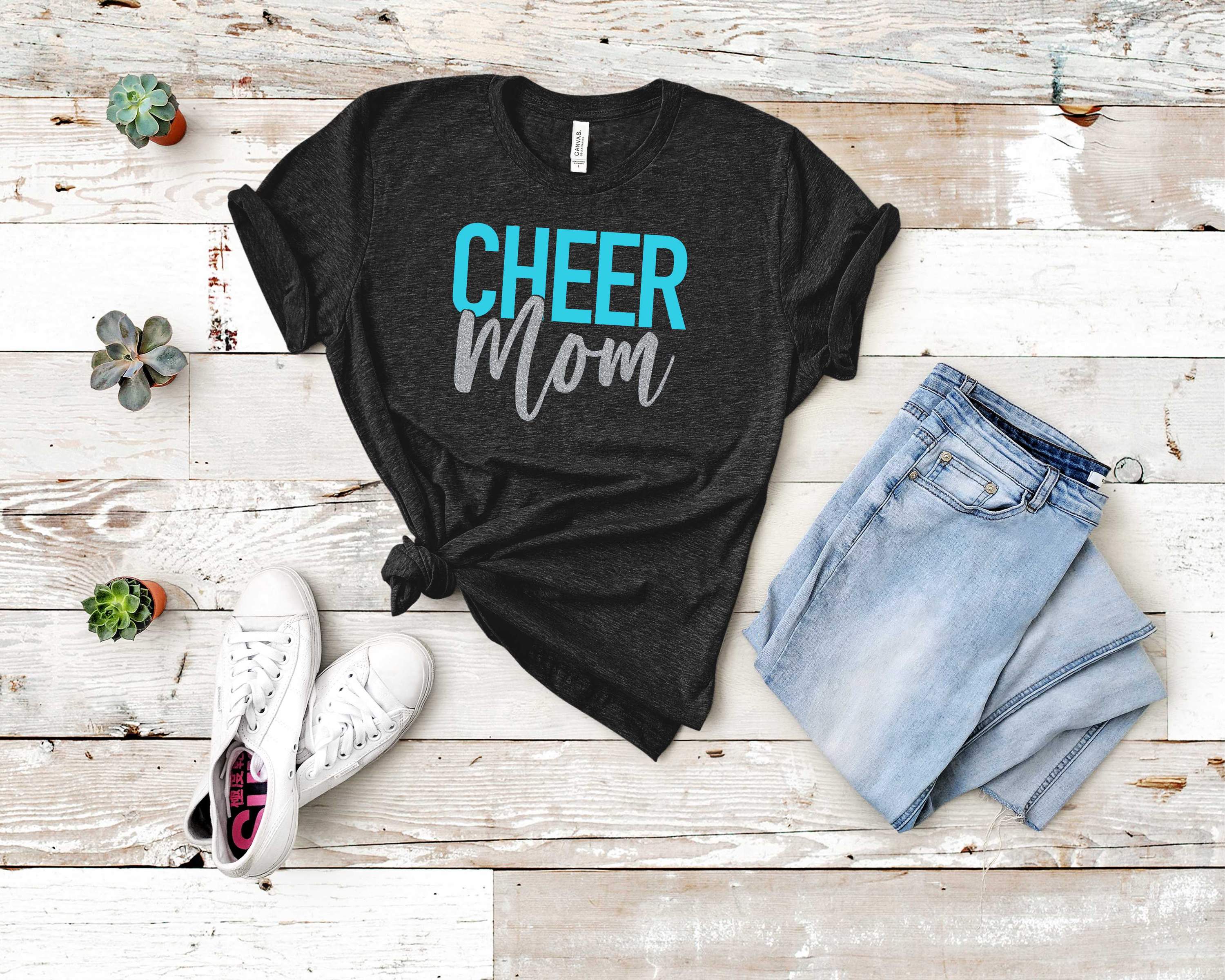 A stylish short-sleeved CHEER MOM graphic t-shirt made from Bella Canvas fabric, featuring bold lettering.