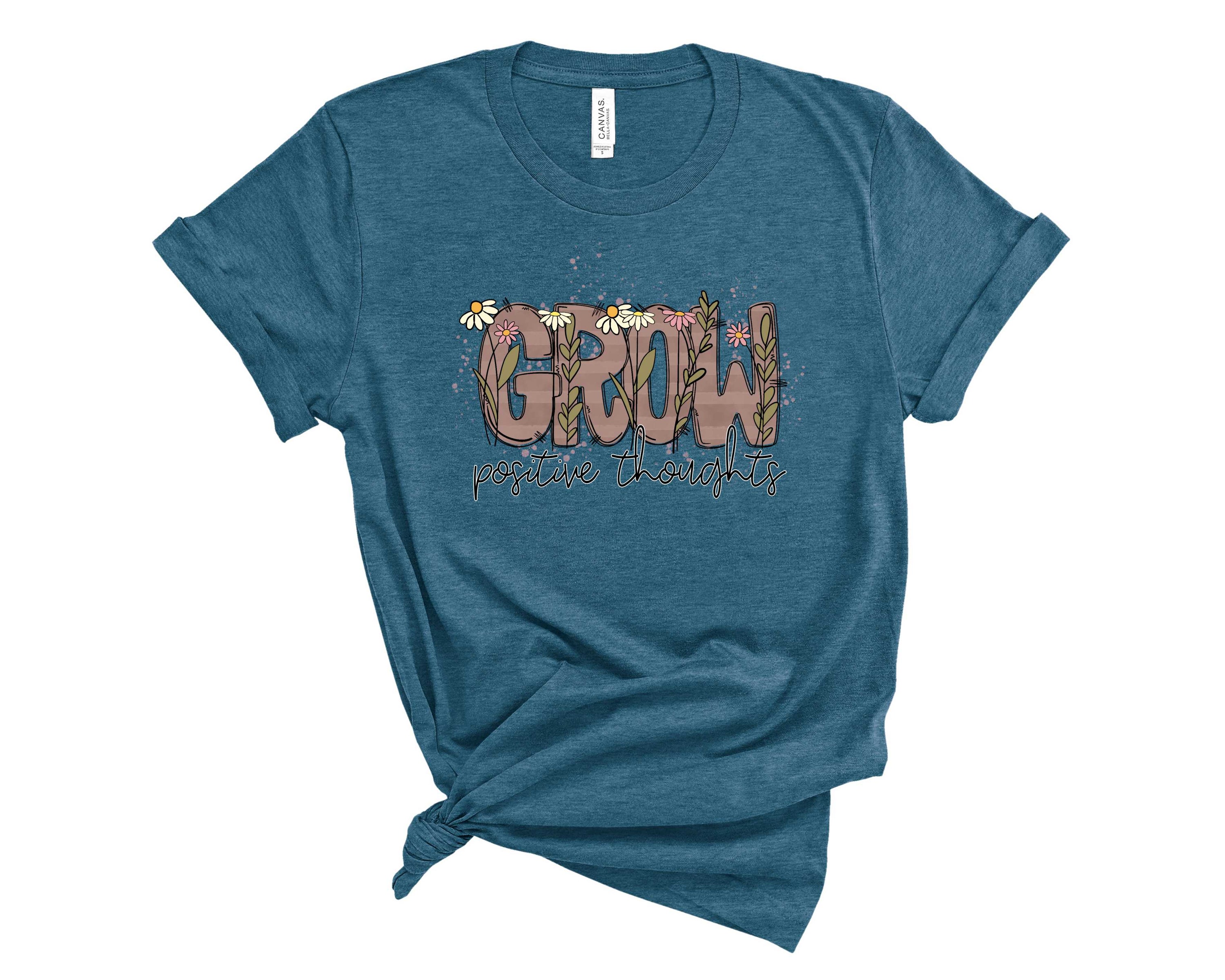A unisex graphic tee featuring the phrase 'Grow Positive Thoughts' in vibrant colors, perfect for casual wear.