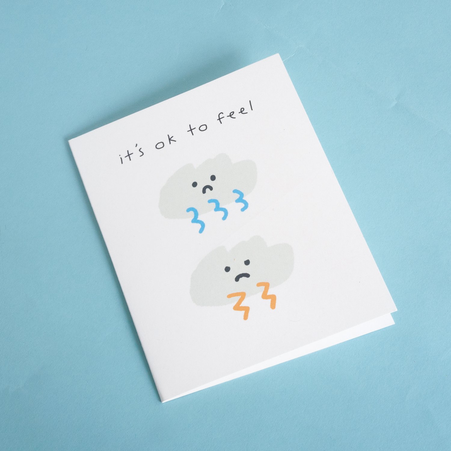 Uplifting illustrated sympathy card titled 'It's Ok to Feel' with a Kraft envelope, showcasing a comforting design.