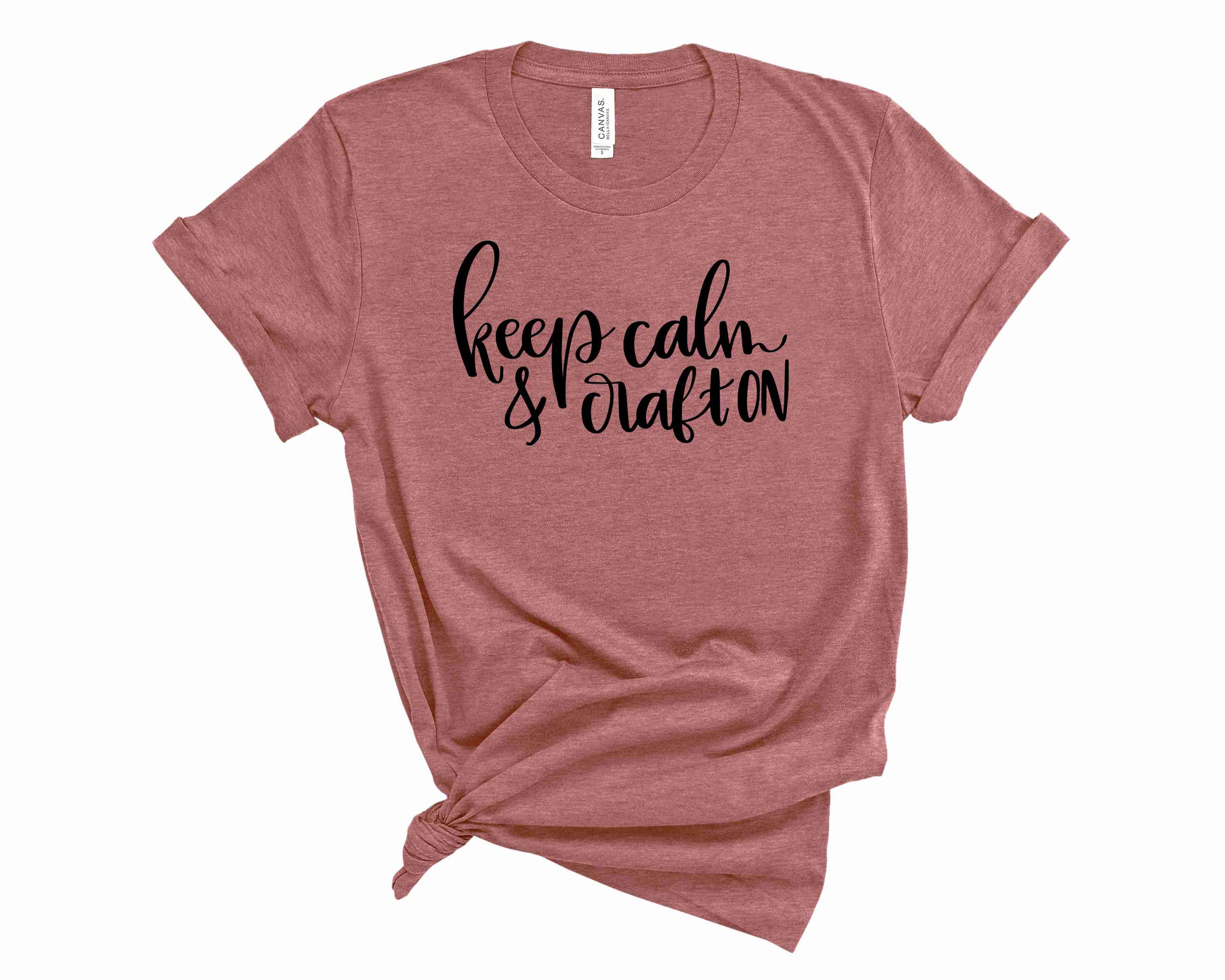 A unisex graphic tee featuring the phrase 'Keep Calm and Craft On' in bold letters, perfect for crafters.