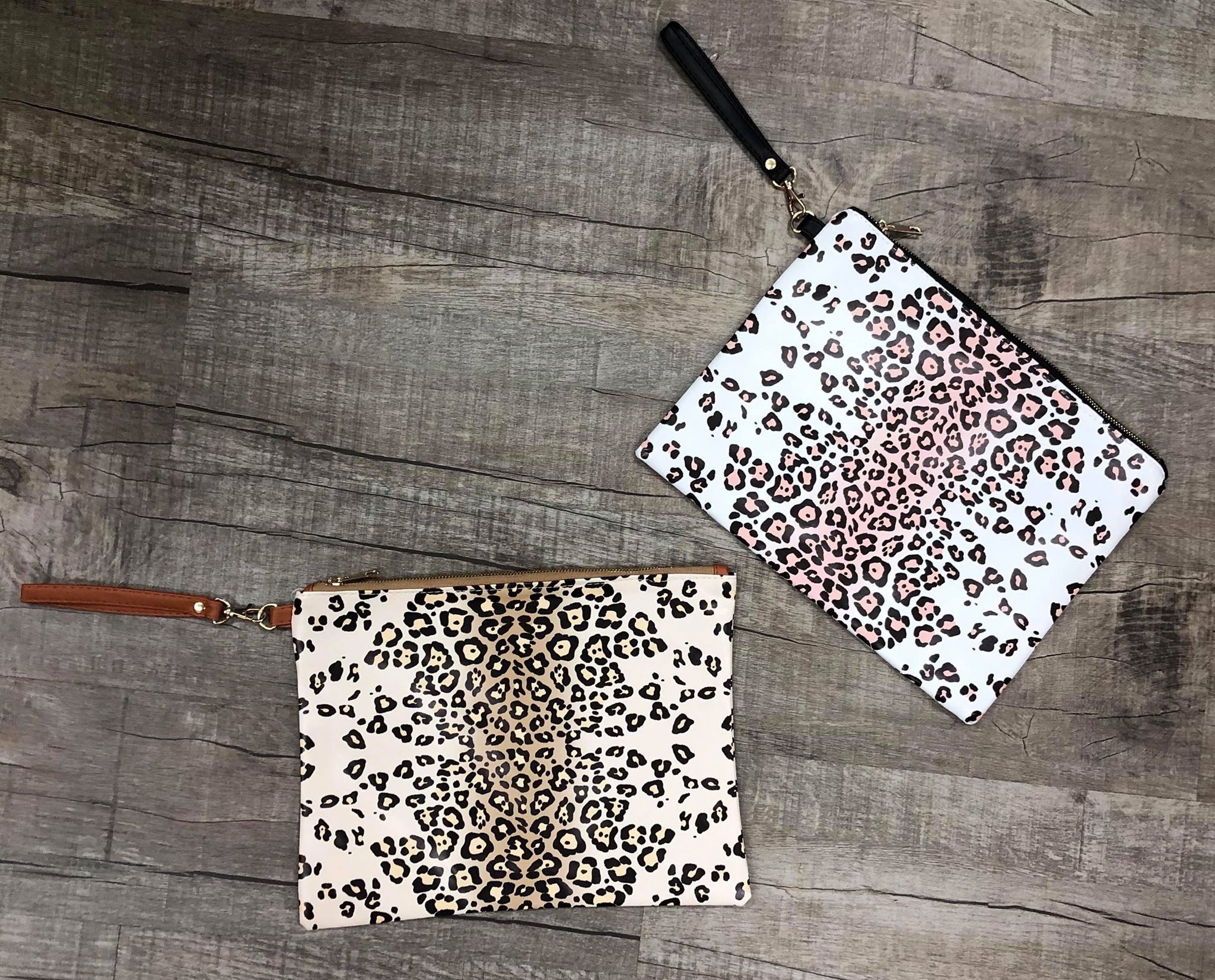 A stylish leopard print wristlet measuring 10in x 13in, featuring a trendy design and a convenient wrist strap.