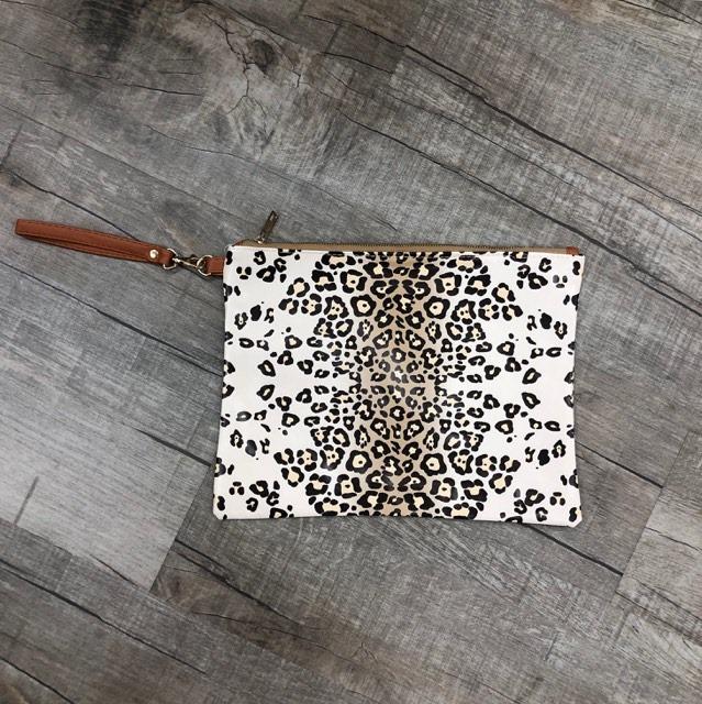A stylish leopard print wristlet measuring 10in x 13in, featuring a trendy design and a convenient wrist strap.