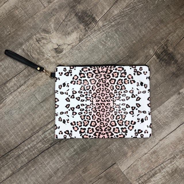 A stylish leopard print wristlet measuring 10in x 13in, featuring a trendy design and a convenient wrist strap.