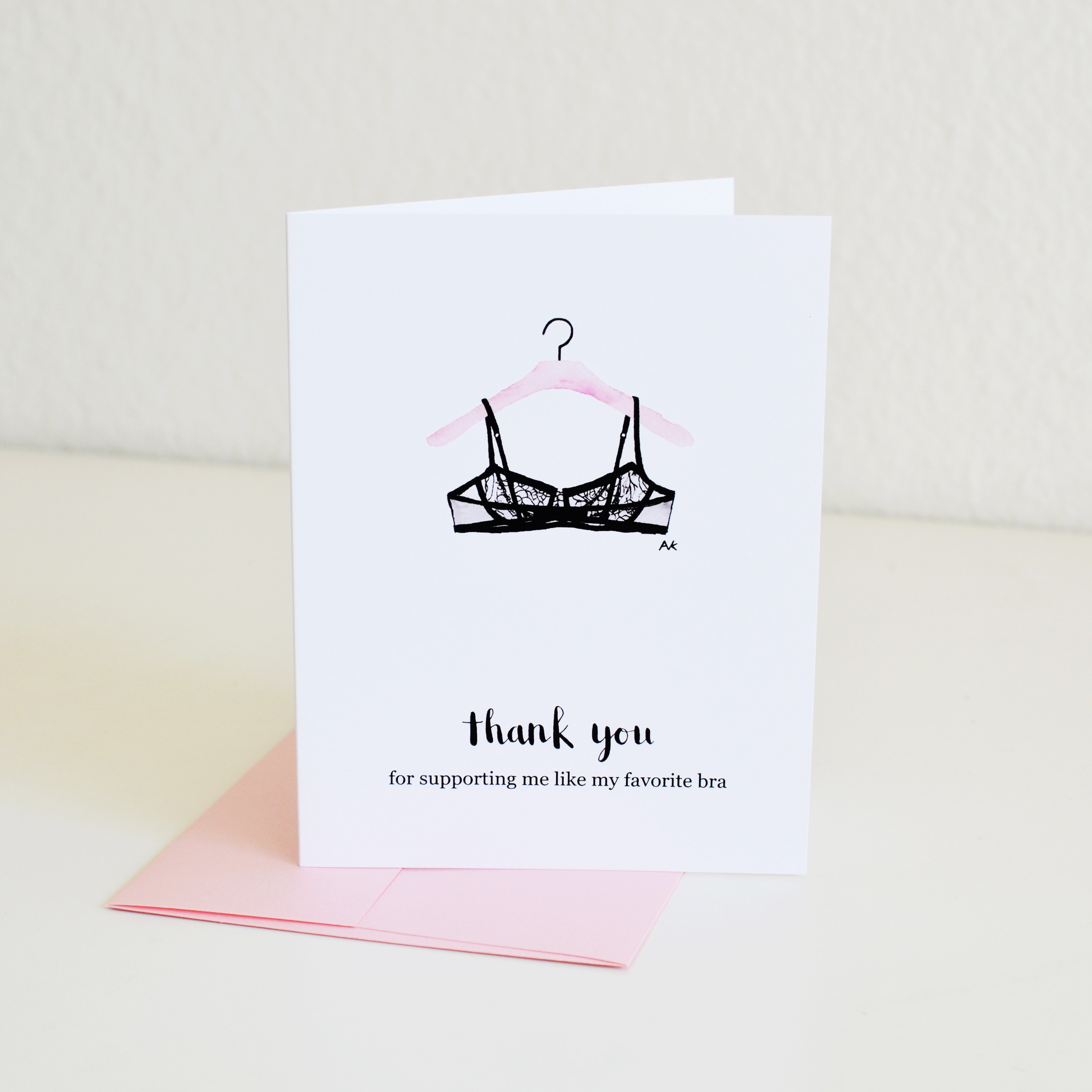 A humorous thank you card featuring a lingerie illustration, with a pink metallic envelope, perfect for expressing gratitude.