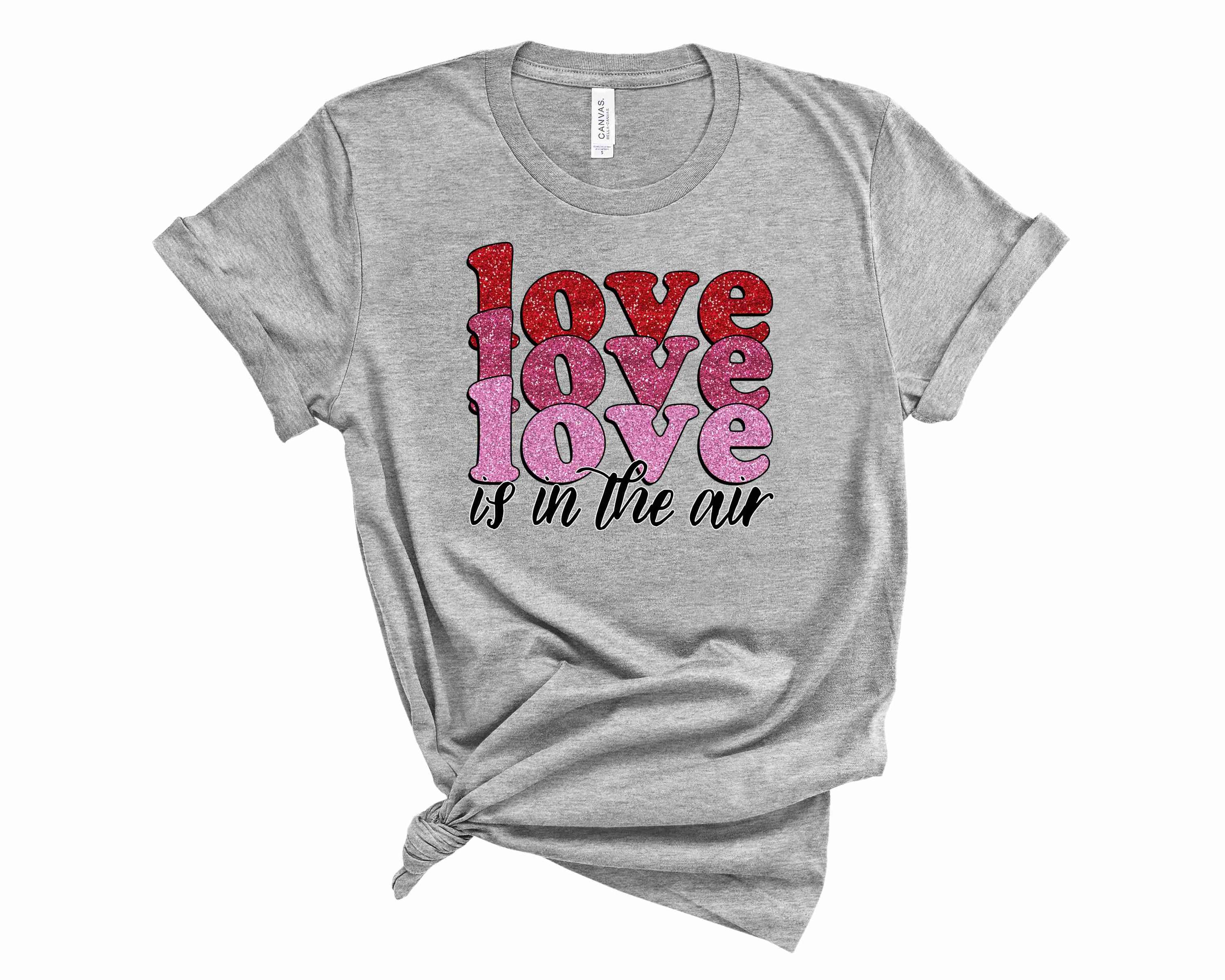 A unisex graphic tee featuring the phrase 'Love is in the Air' in a stylish font, perfect for casual wear.
