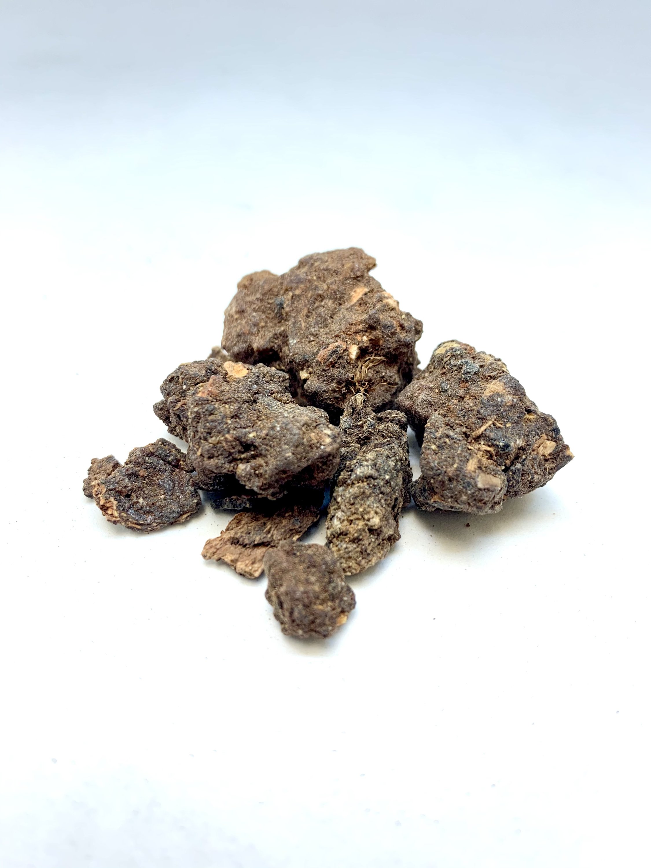 A small container of Myrrh resin, showcasing its natural earthy color and texture, ideal for burning as incense.