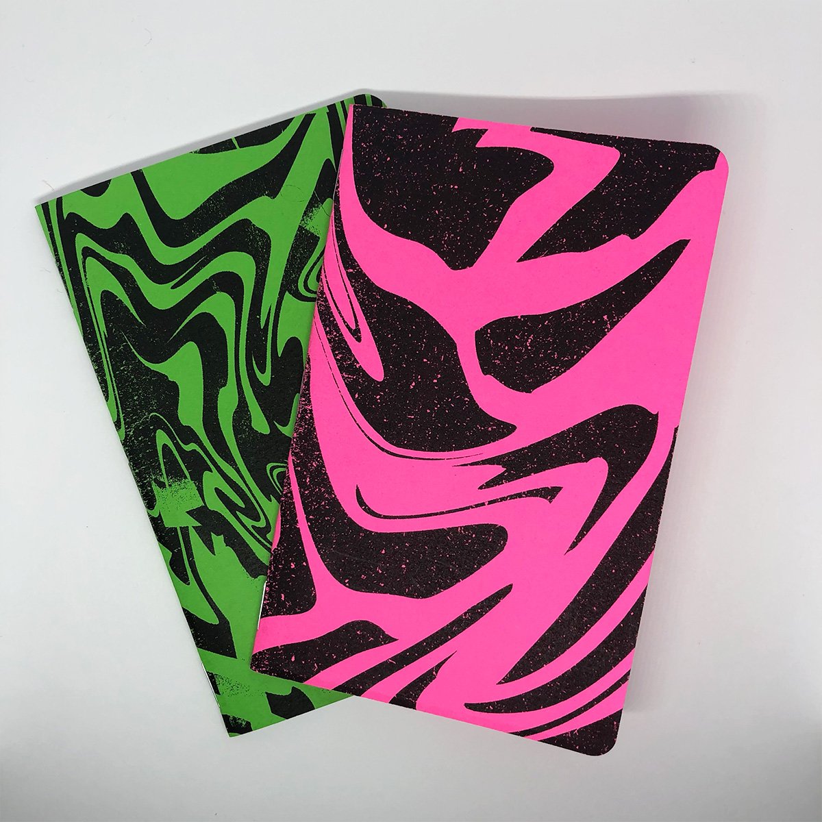 Two Neon Marble grid memo books featuring unique marble patterns on colorful covers, showcasing their compact size and high-quality design.