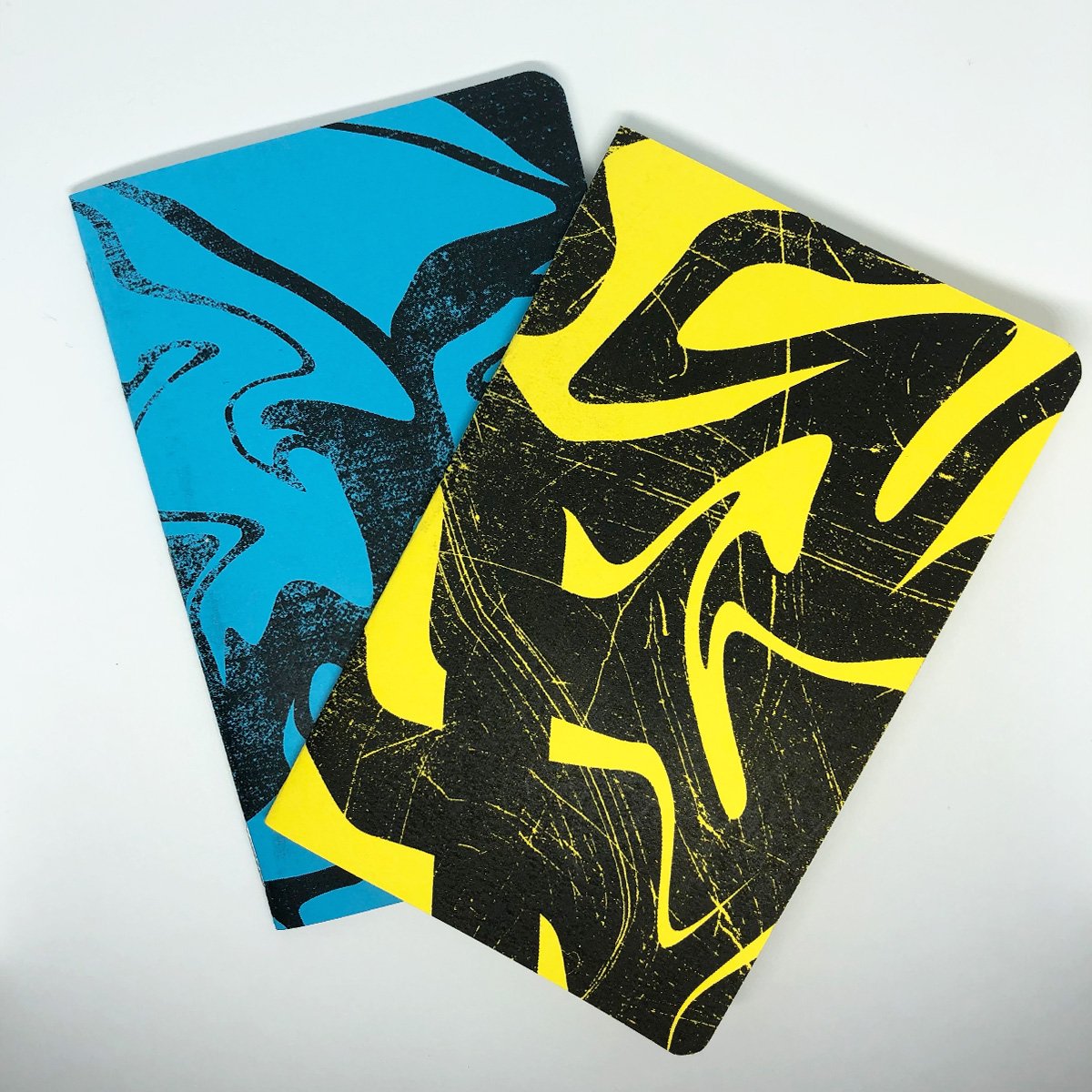 Two Neon Marble grid memo books featuring unique marble patterns on colorful covers, showcasing their compact size and high-quality design.