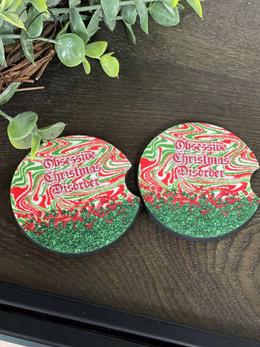 A set of two neoprene car coasters featuring a festive Obsessive Christmas Disorder design, perfect for holiday-themed car decor.