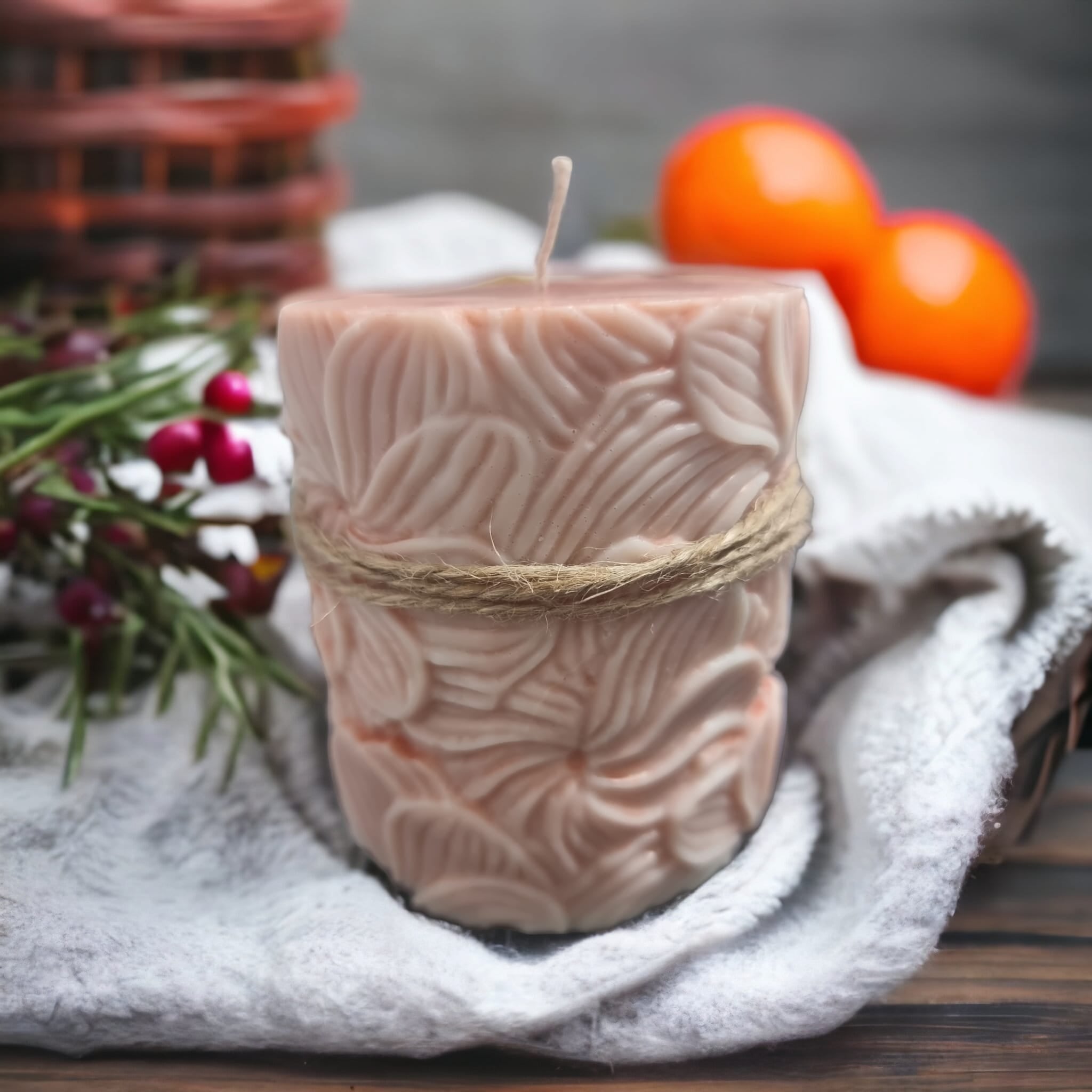 A beautifully crafted pillar candle with vibrant orange and cranberry colors, emitting a warm glow, perfect for seasonal decor.