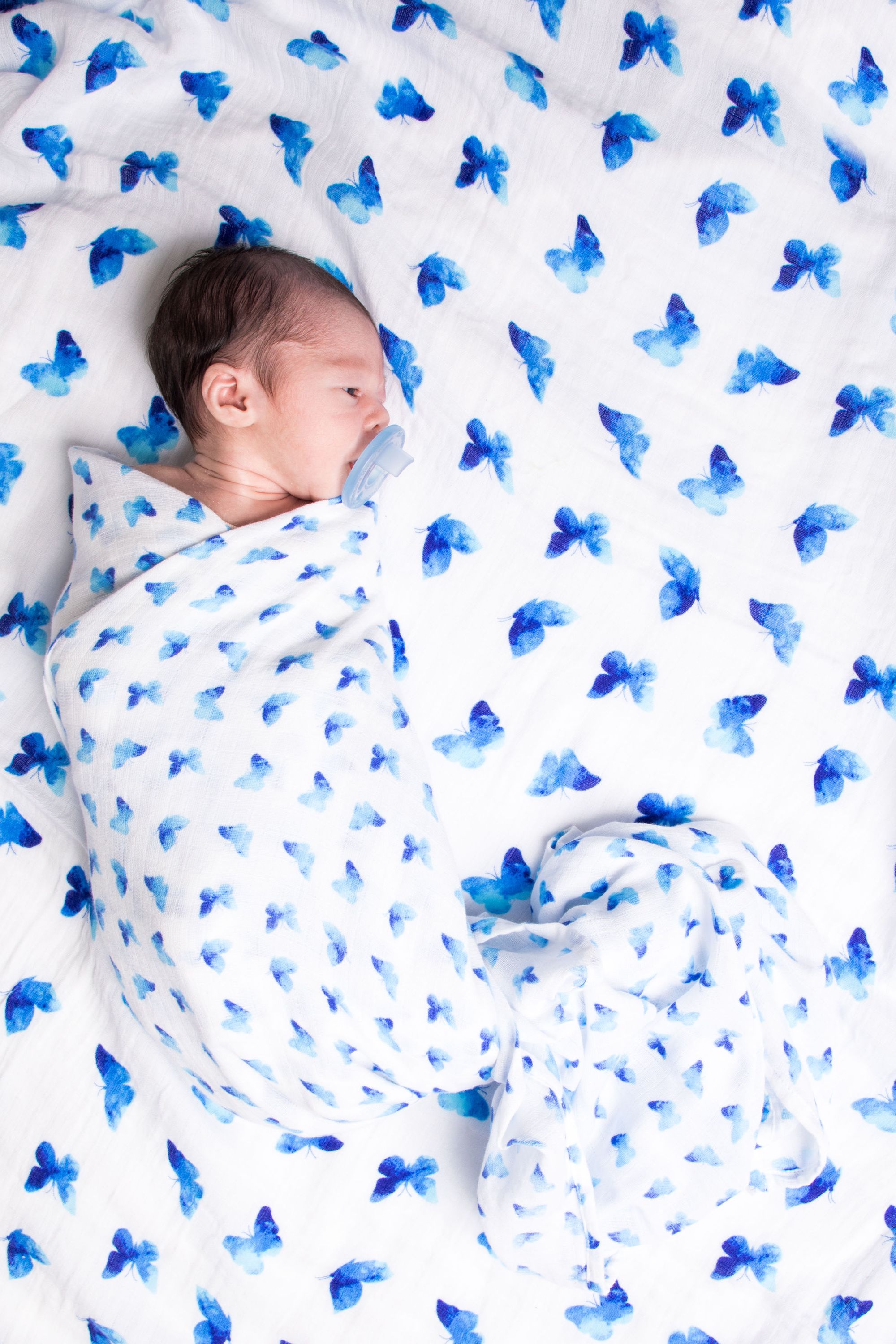 Luxuriously soft Organic Swaddle in Blue Butterfly design, made from GOTS certified organic cotton, perfect for babies.