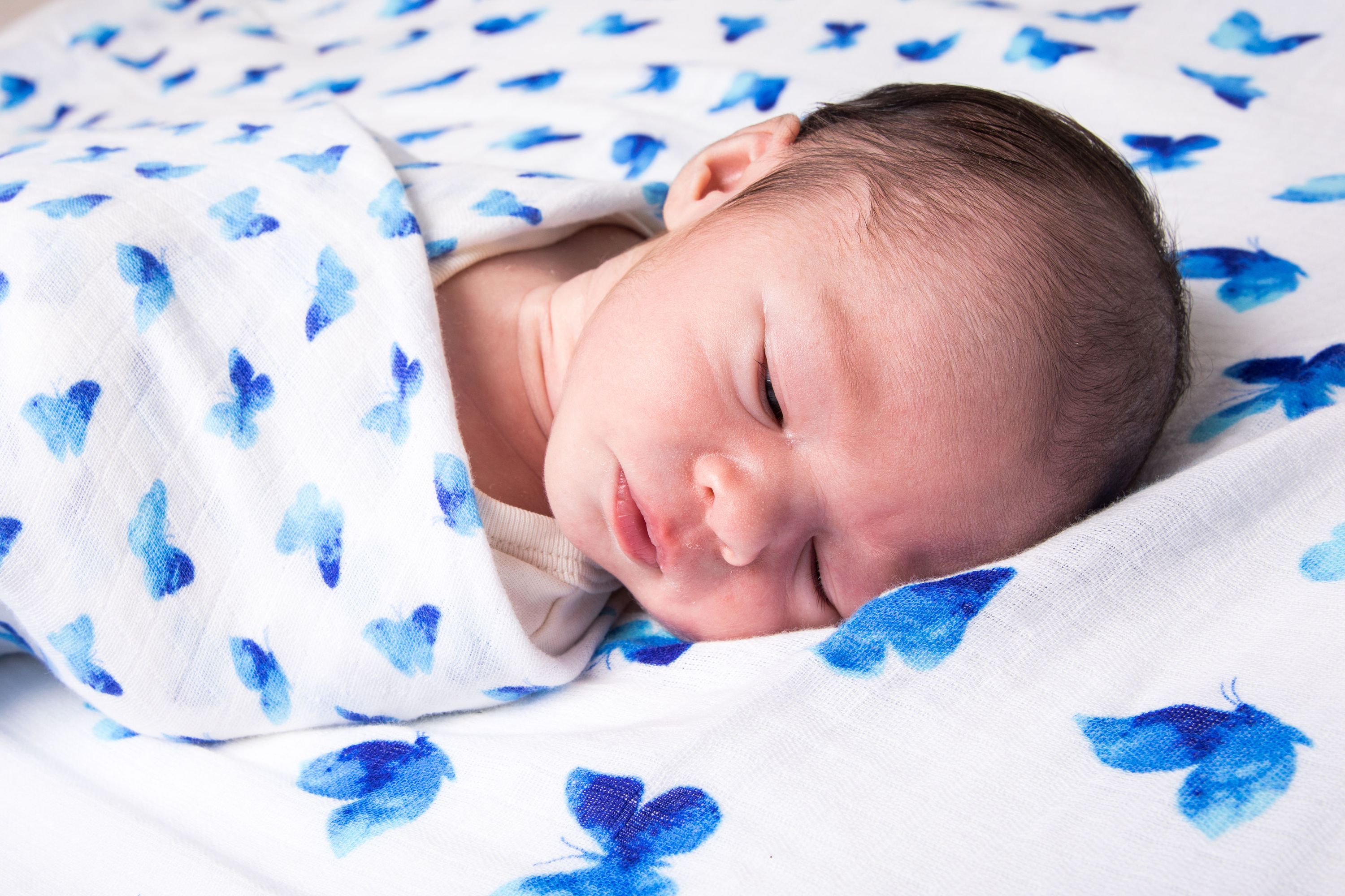 Luxuriously soft Organic Swaddle in Blue Butterfly design, made from GOTS certified organic cotton, perfect for babies.