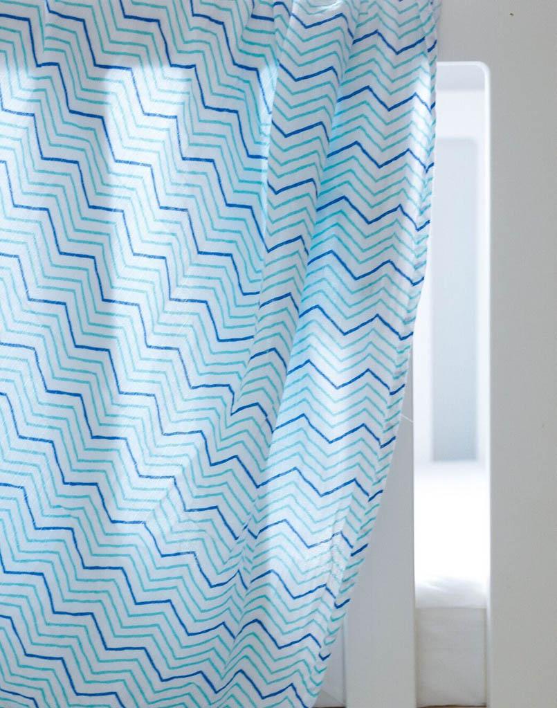 Luxuriously soft organic cotton swaddle in Chevron design, perfect for snuggling and versatile use.