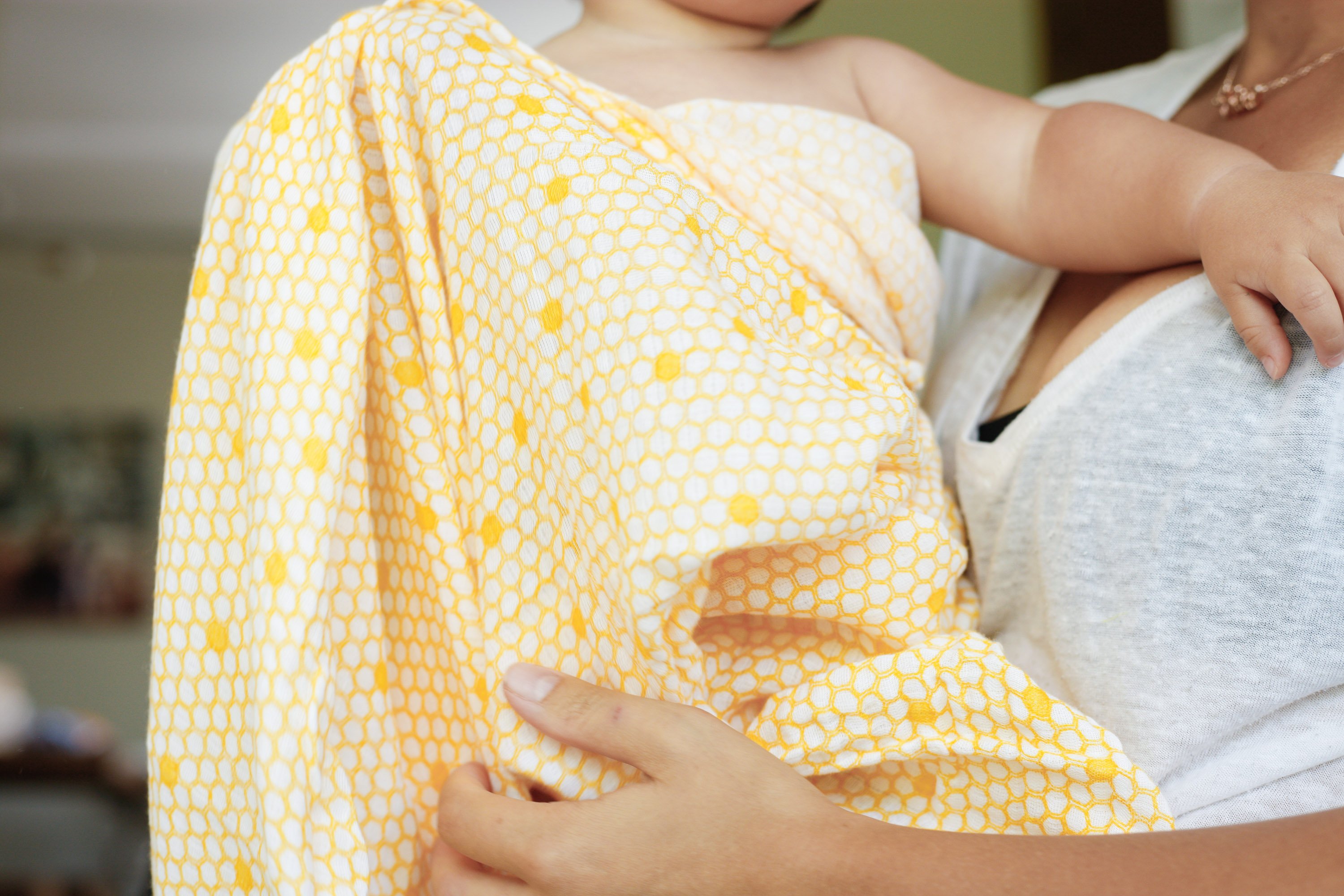 A soft and breathable organic cotton swaddle in a stylish hive pattern, perfect for wrapping babies comfortably.