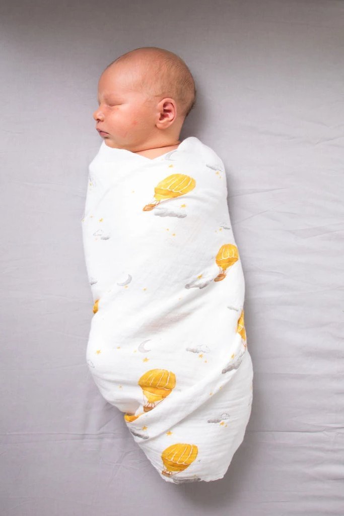 Organic cotton swaddle featuring a colorful hot air balloon design, soft and breathable fabric, perfect for babies.