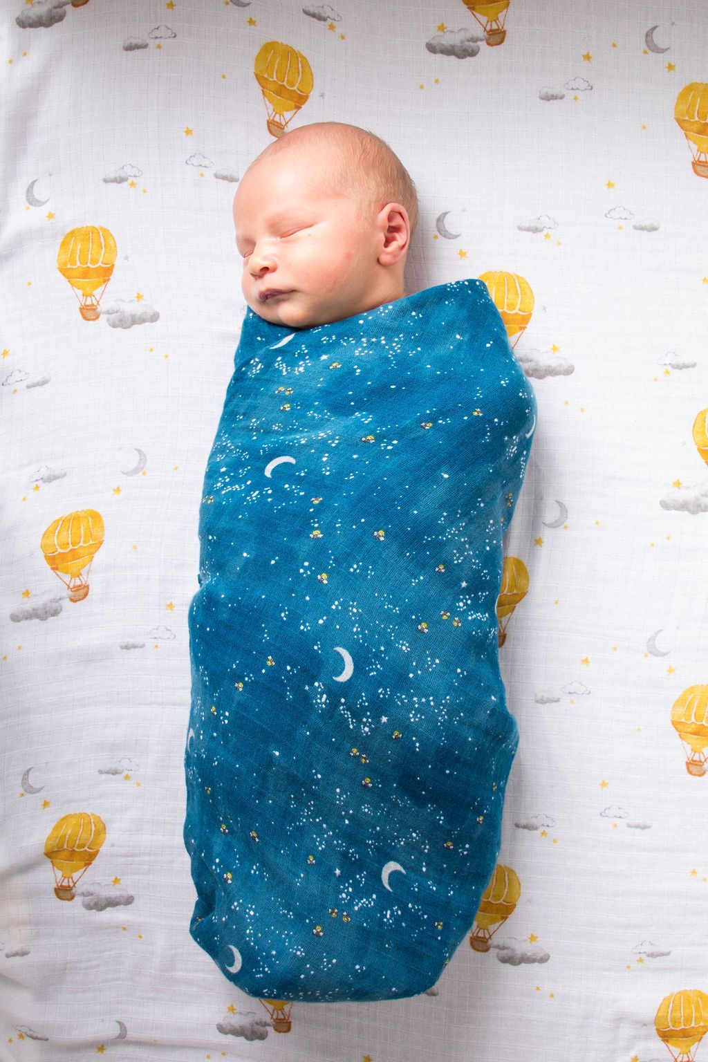 Organic cotton swaddle featuring a colorful hot air balloon design, soft and breathable fabric, perfect for babies.