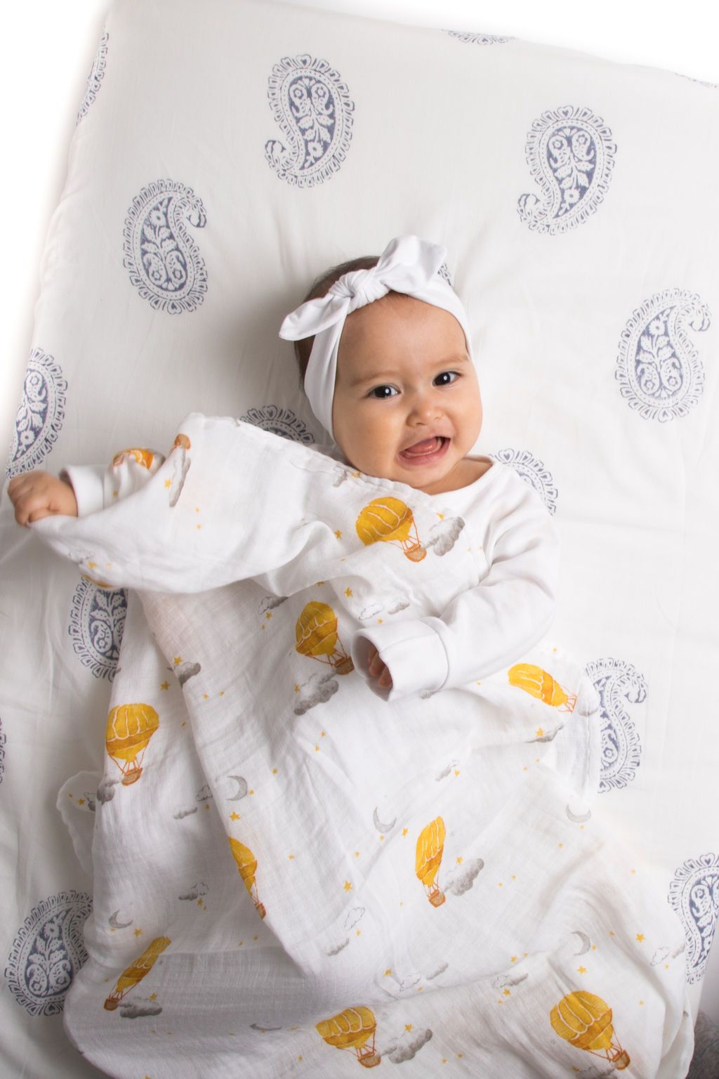Organic cotton swaddle featuring a colorful hot air balloon design, soft and breathable fabric, perfect for babies.