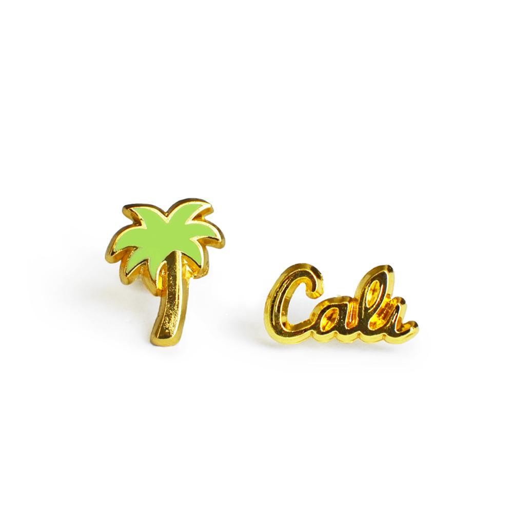 A pair of stylish Palm Tree & Cali Earrings made of hard enamel, featuring a palm tree design and a butterfly stopper.