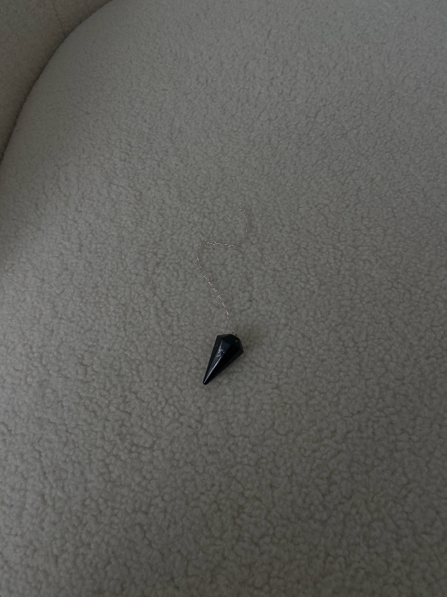 PENDULE TOURMALINE pendulum with a crystal design, showcasing its protective properties and intuitive guidance features.