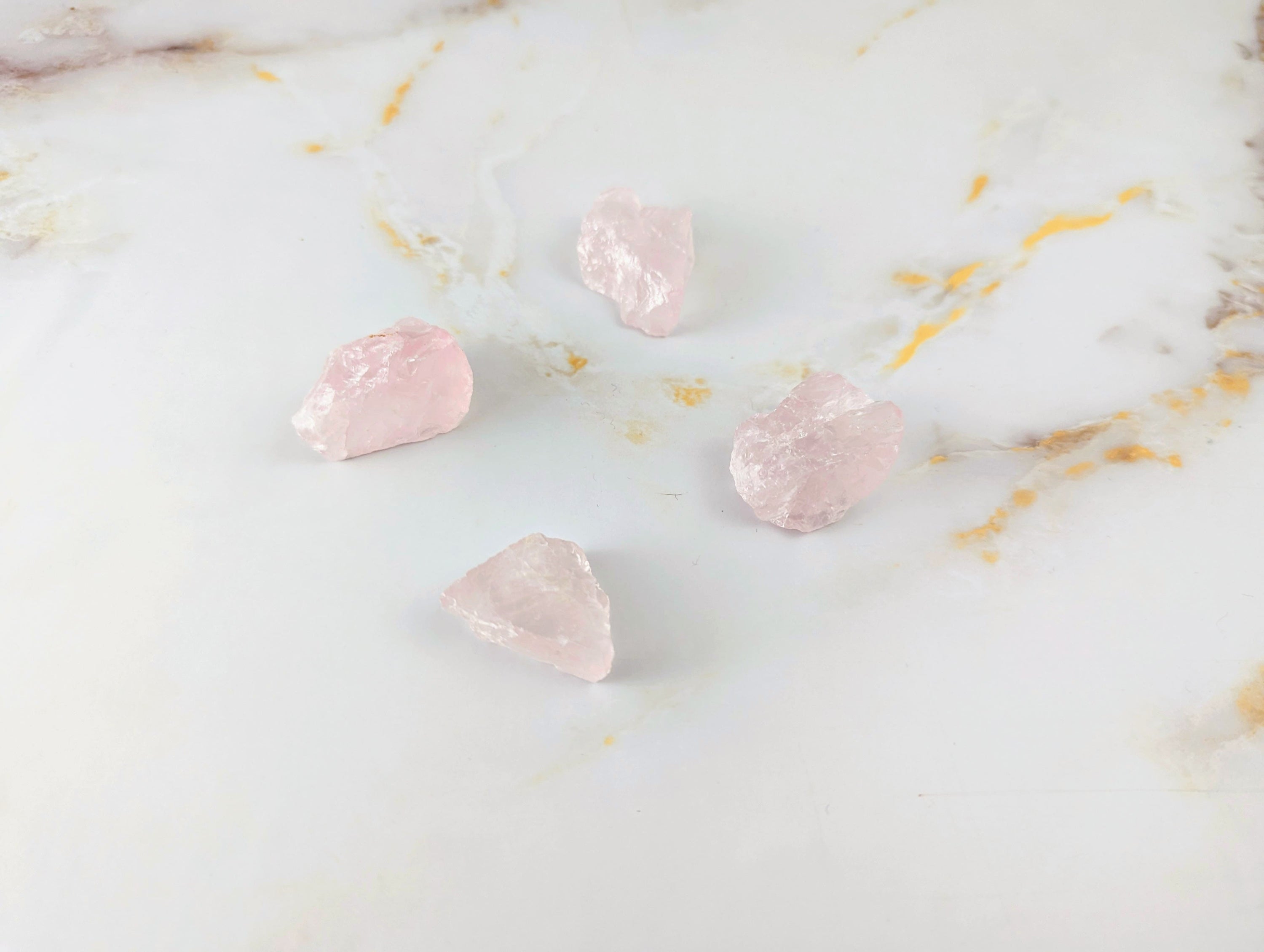 Pierre brute en Quartz Rose de taille moyenne, avec une belle couleur translucide, posée sur une surface naturelle.