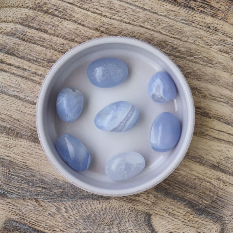 Pierre roulée en Calcédoine Blue Lace, présentant des motifs délicats et une couleur bleu clair apaisante.