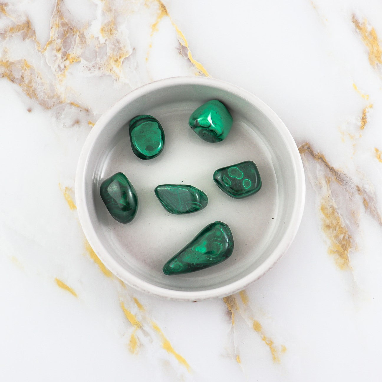 Pierre roulée en Malachite naturelle, affichant des nuances de vert clair à vert profond, idéale pour la lithothérapie.