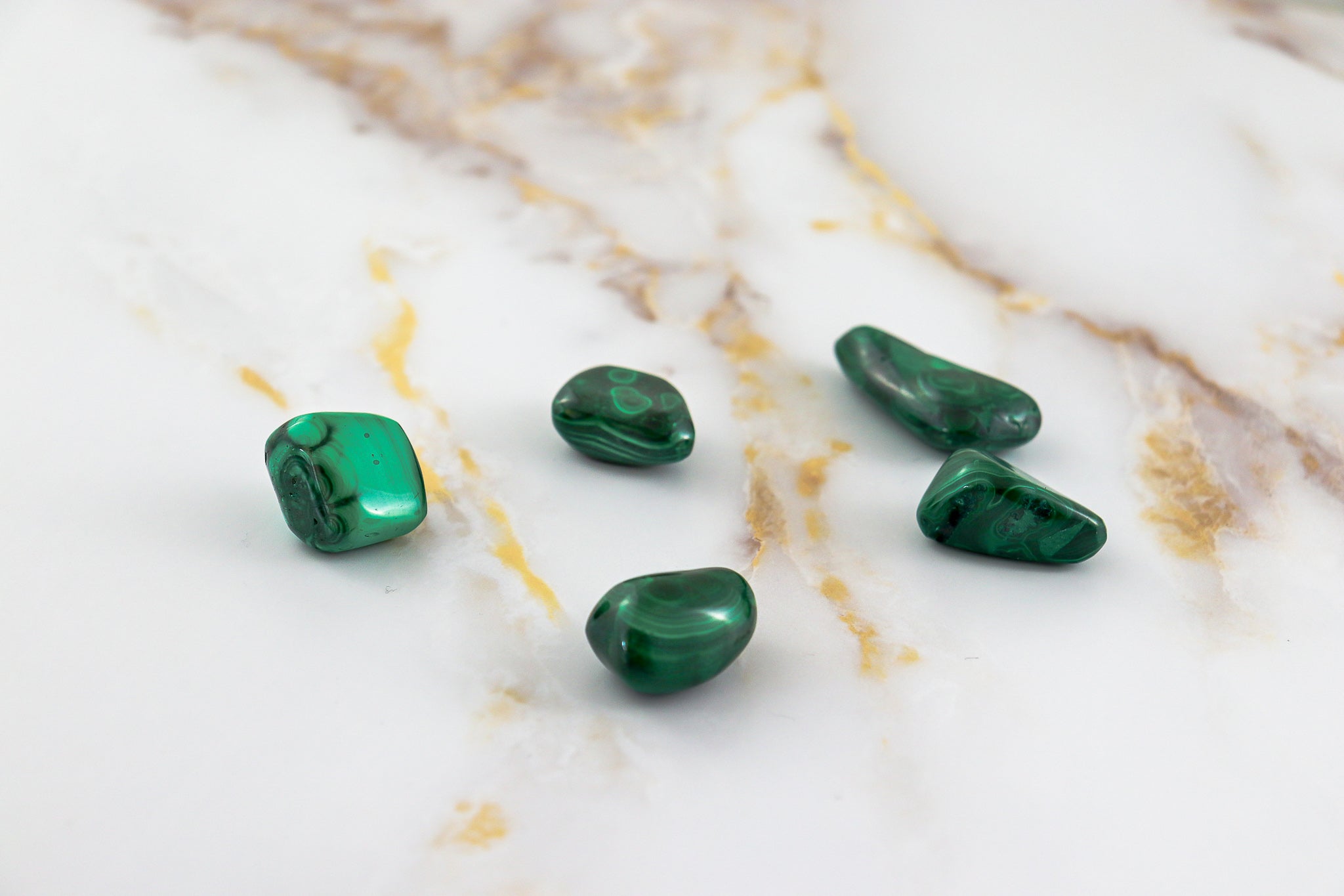 Pierre roulée en Malachite naturelle, affichant des nuances de vert clair à vert profond, idéale pour la lithothérapie.