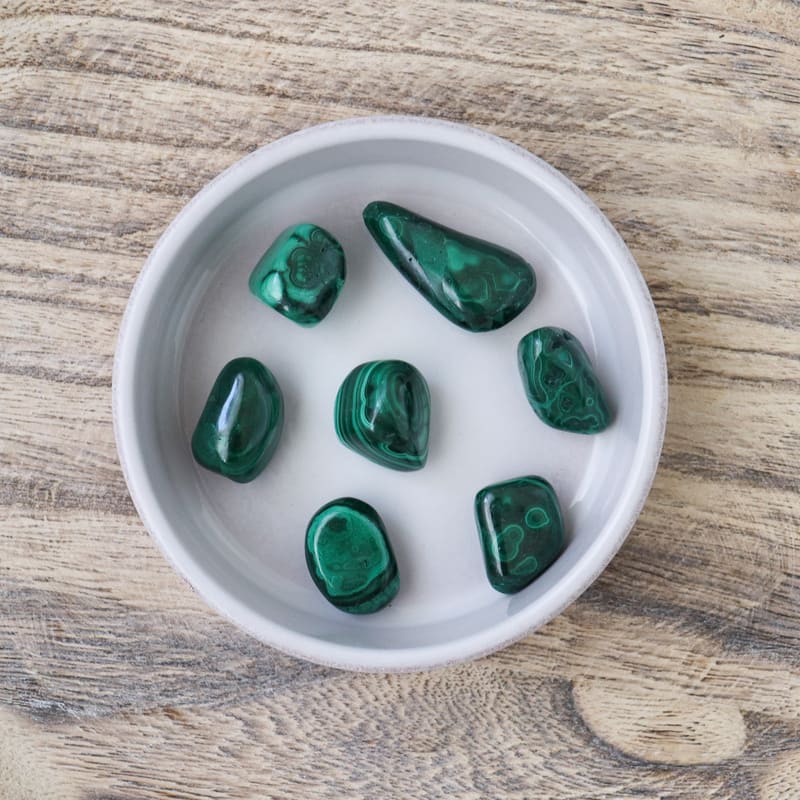 Pierre roulée en Malachite naturelle, affichant des nuances de vert clair à vert profond, idéale pour la lithothérapie.