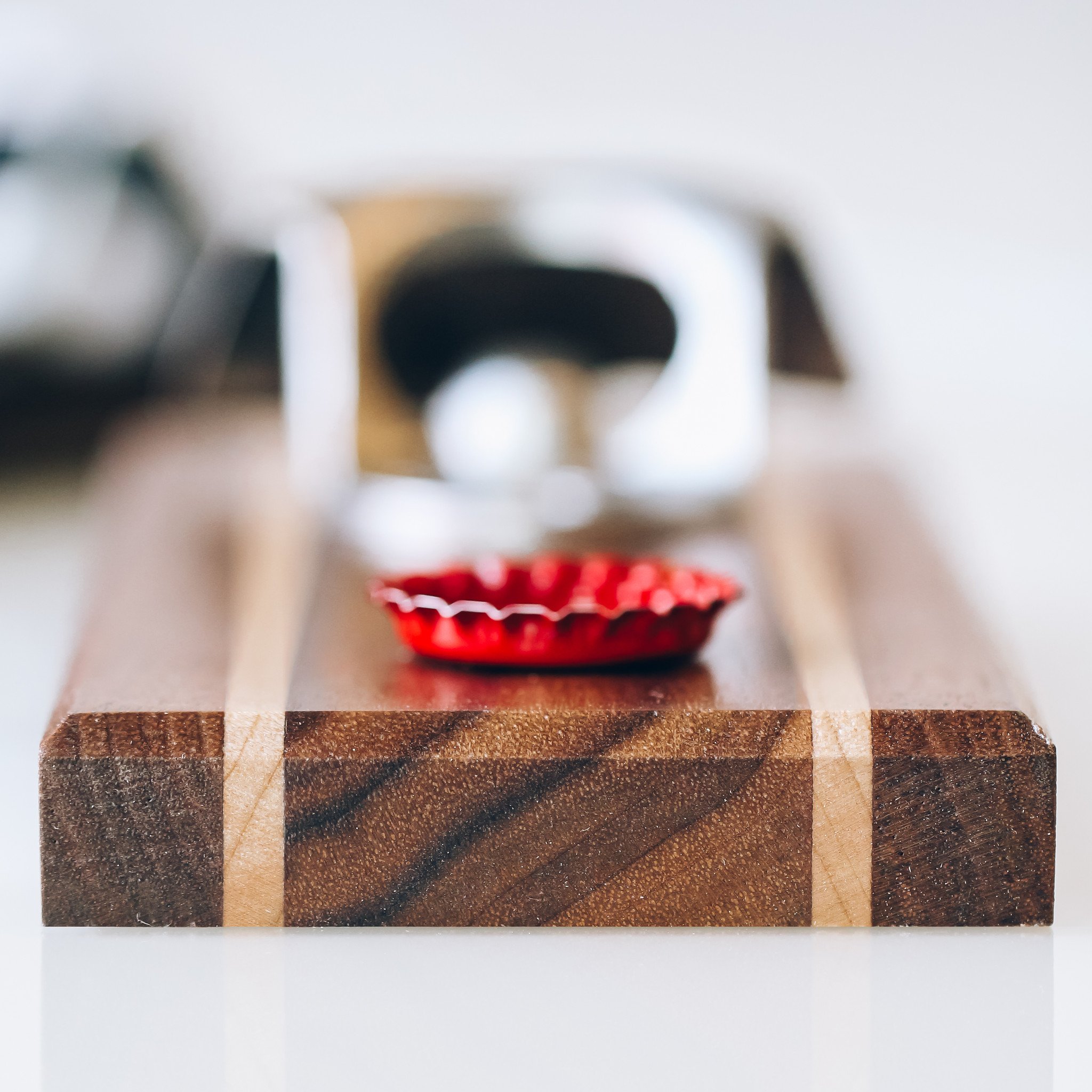 Handcrafted Pilsner Bottle Opener made from quartersawn walnut wood with maple inlays, featuring a magnetic and wall mounting option.