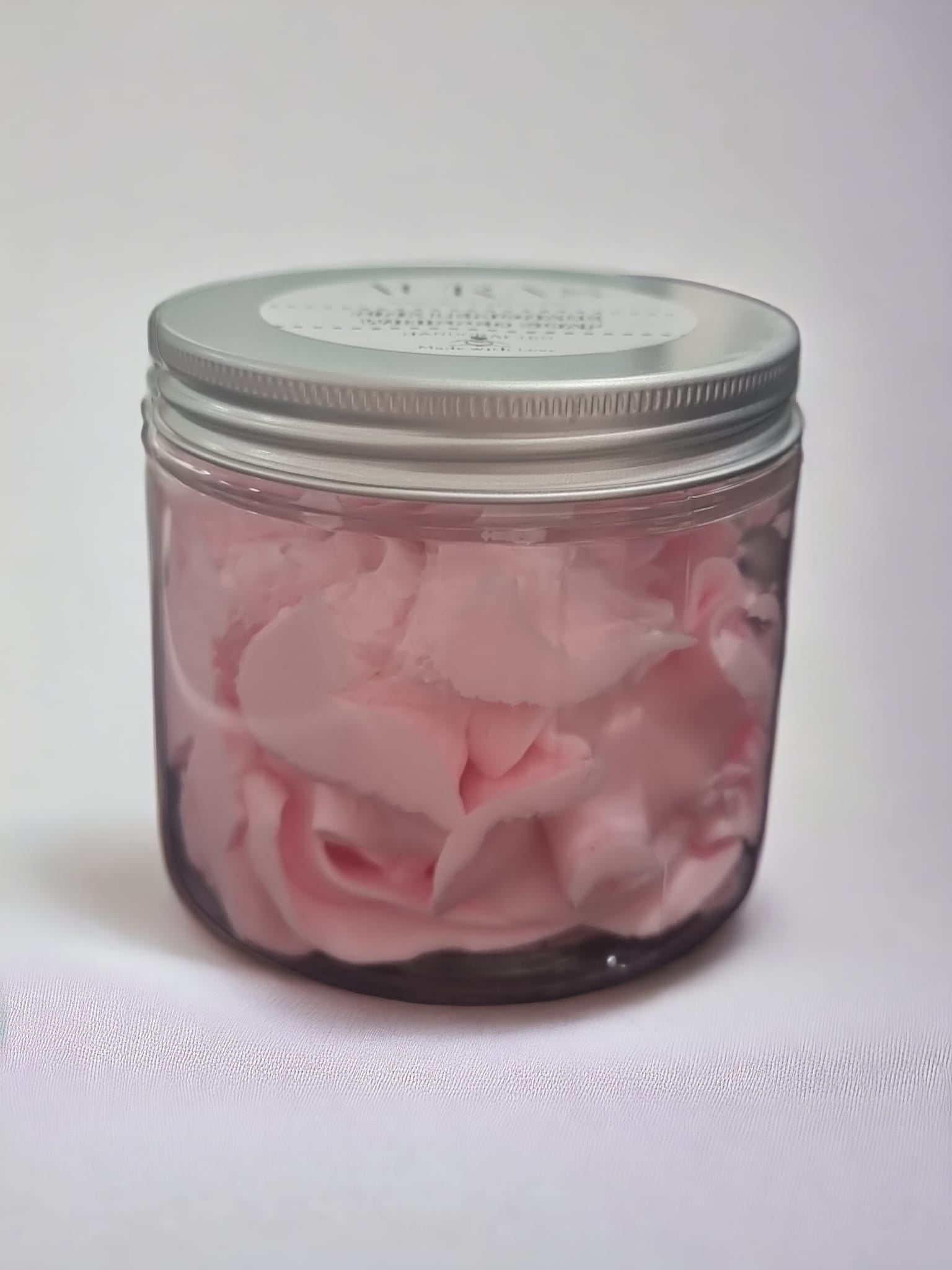 A jar of Pink Lemonade Whipped Soap with a fluffy texture and vibrant pink color, evoking a refreshing summer vibe.