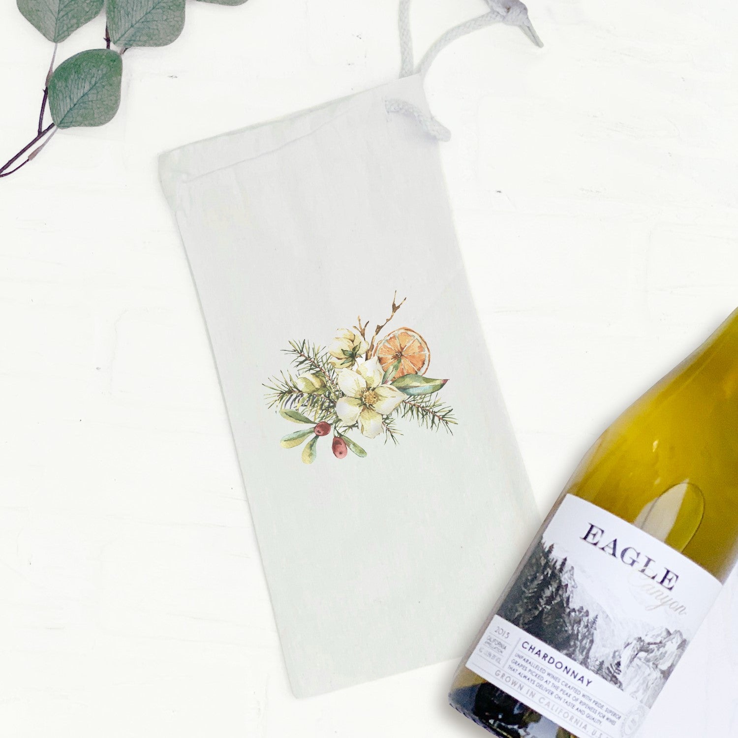 Poinsettia Holly and Orange Bouquet canvas wine bag featuring a vibrant floral design and drawstring closure, perfect for gifting wine.