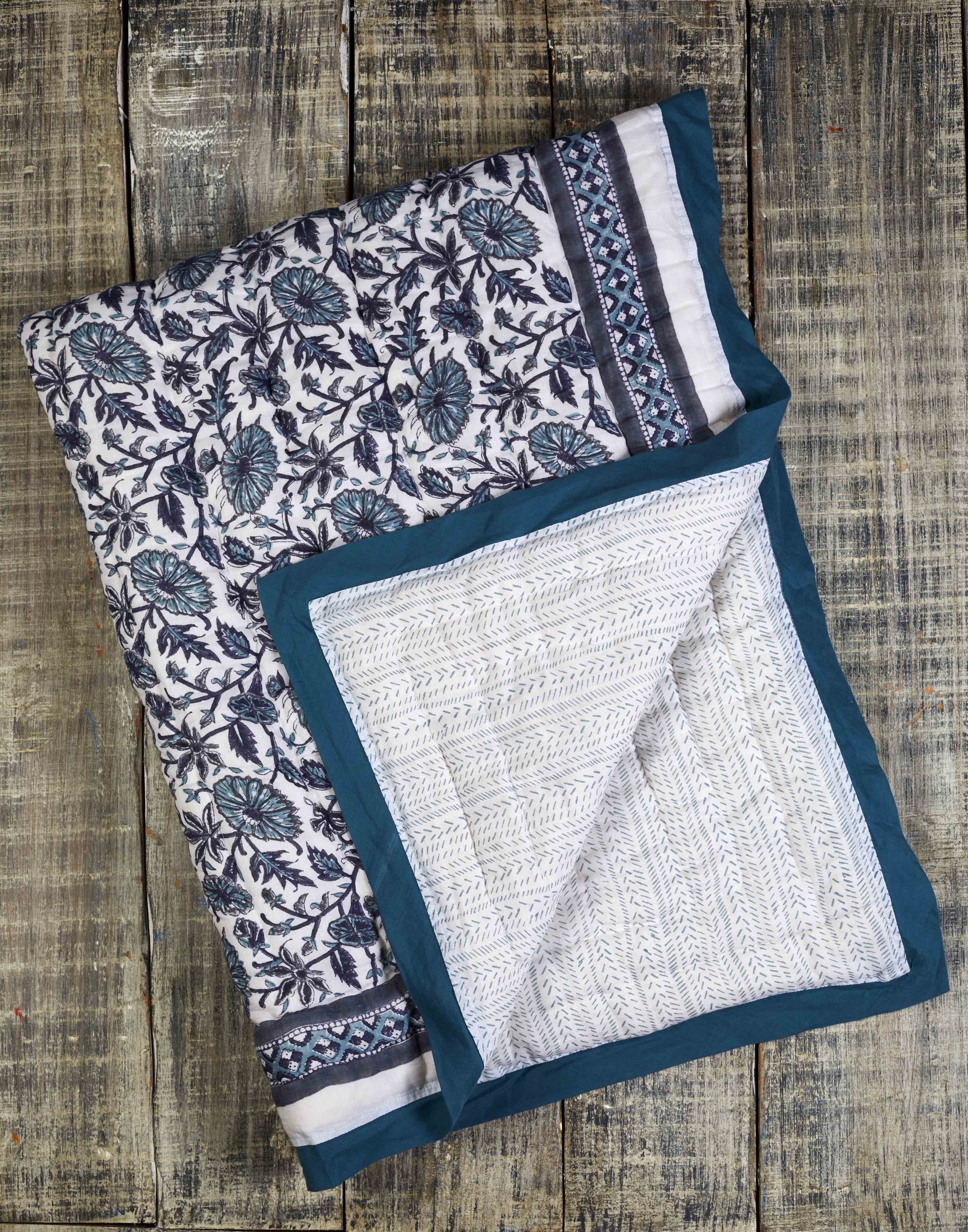 Provence Blue Cotton Quilt featuring intricate hand-stitched designs and a soft, luxurious texture, perfect for any bedroom decor.