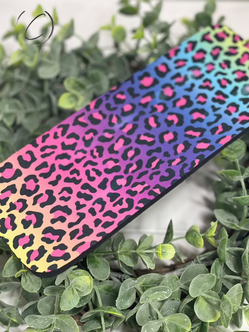Rainbow Leopard Slap Wrap Can Cooler featuring vibrant colors and a unique design, perfect for keeping drinks cold.