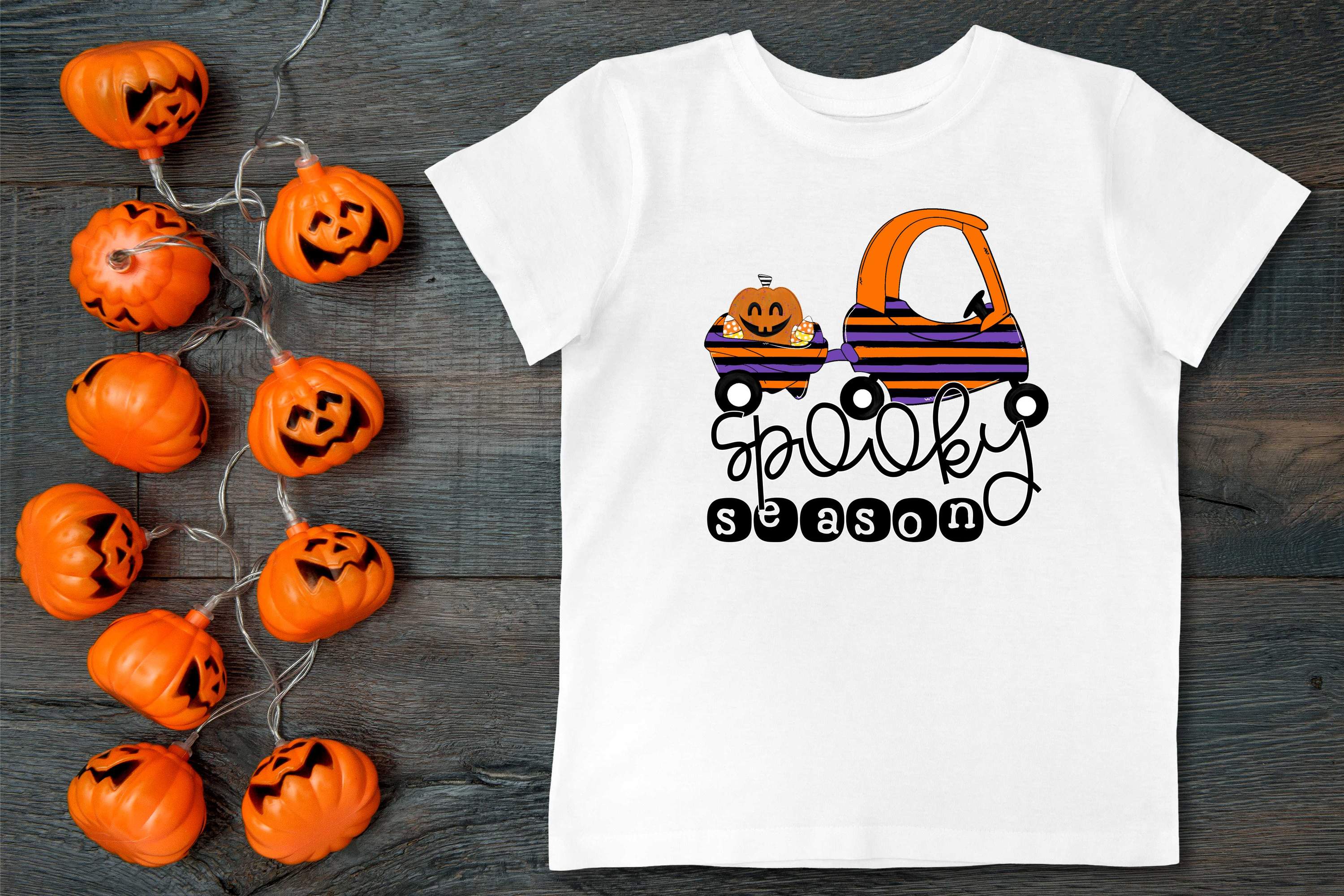 A colorful Spooky Season Graphic Tee for kids featuring Halloween-themed designs like ghosts and pumpkins.