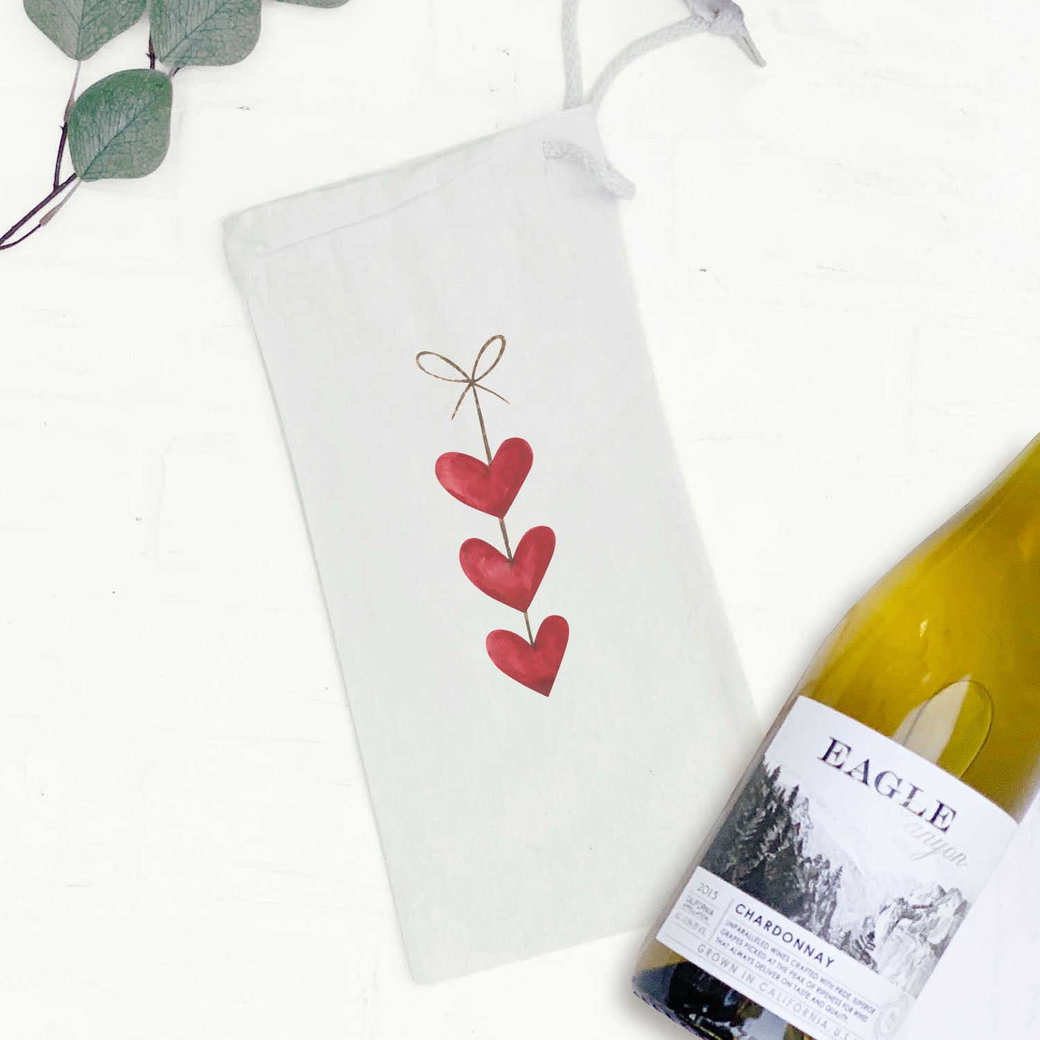 A stylish String of Hearts Canvas Wine Bag featuring a whimsical heart design, perfect for carrying a 750mL wine bottle.