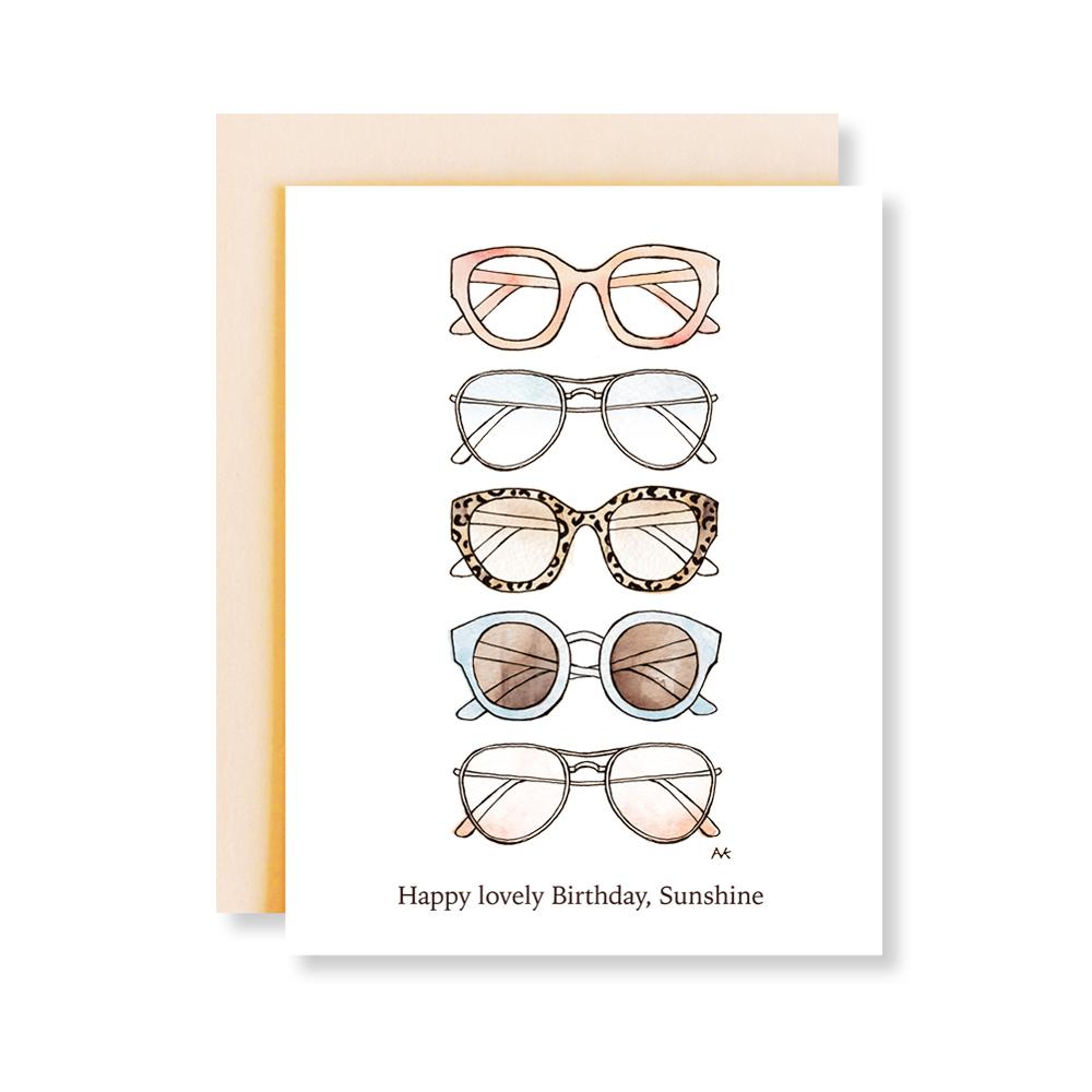 A stylish birthday card featuring a sunglasses fashion illustration, with a peach metallic envelope.