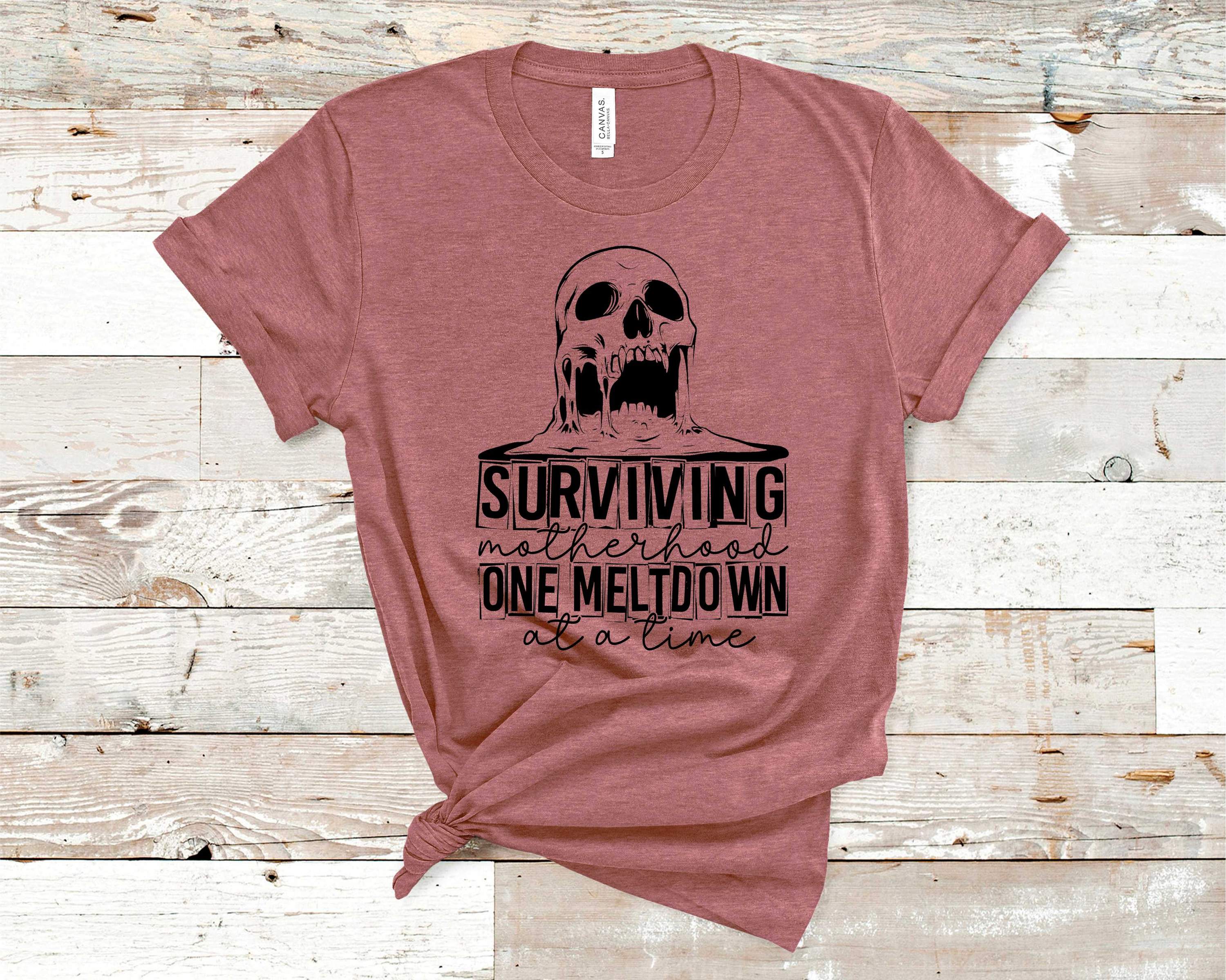 Surviving Motherhood Graphic Tee featuring a stylish design on a soft Bella Canvas fabric.