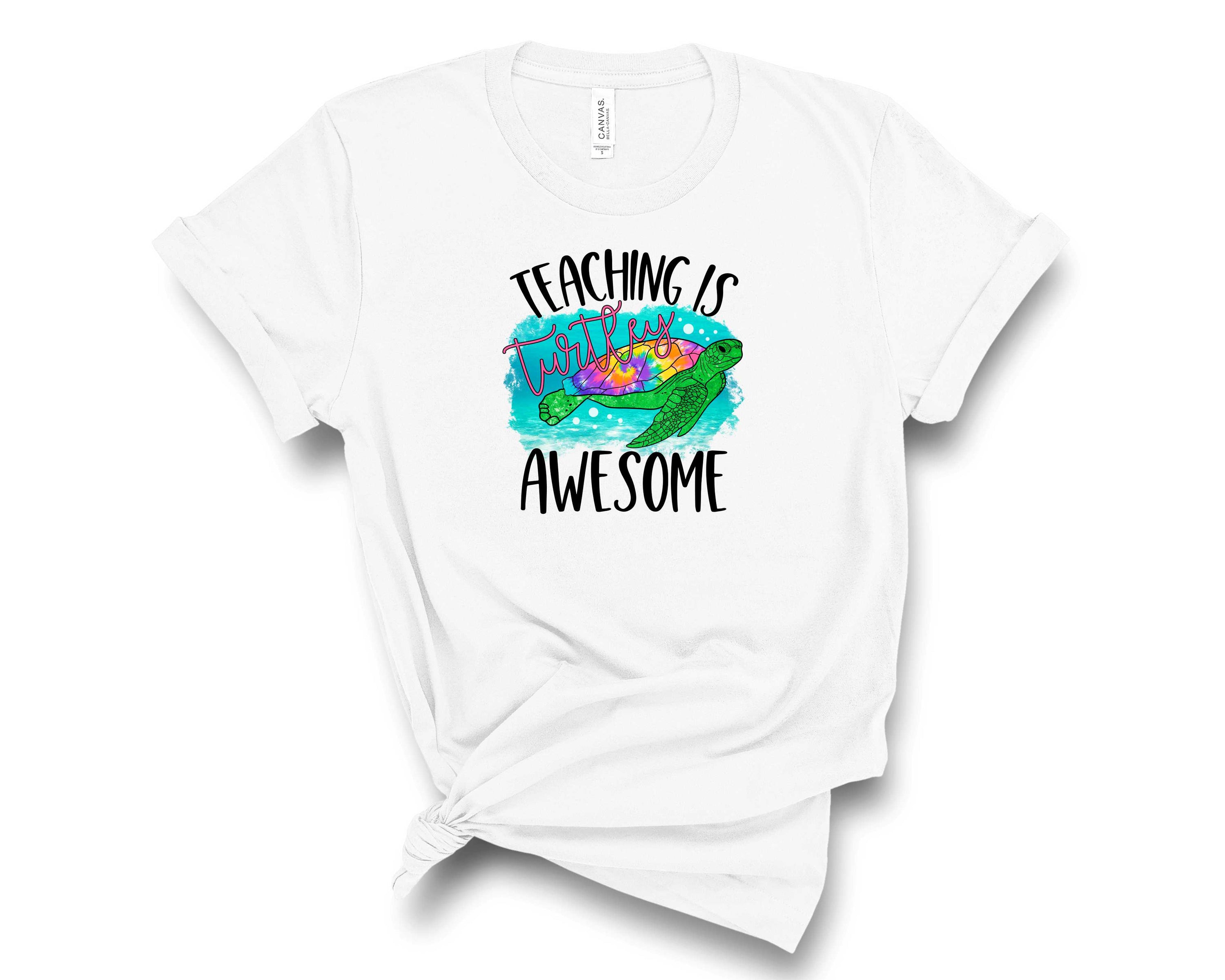 A unisex graphic tee featuring a cute turtle design with the text 'Teaching is Turtley Awesome', perfect for educators.