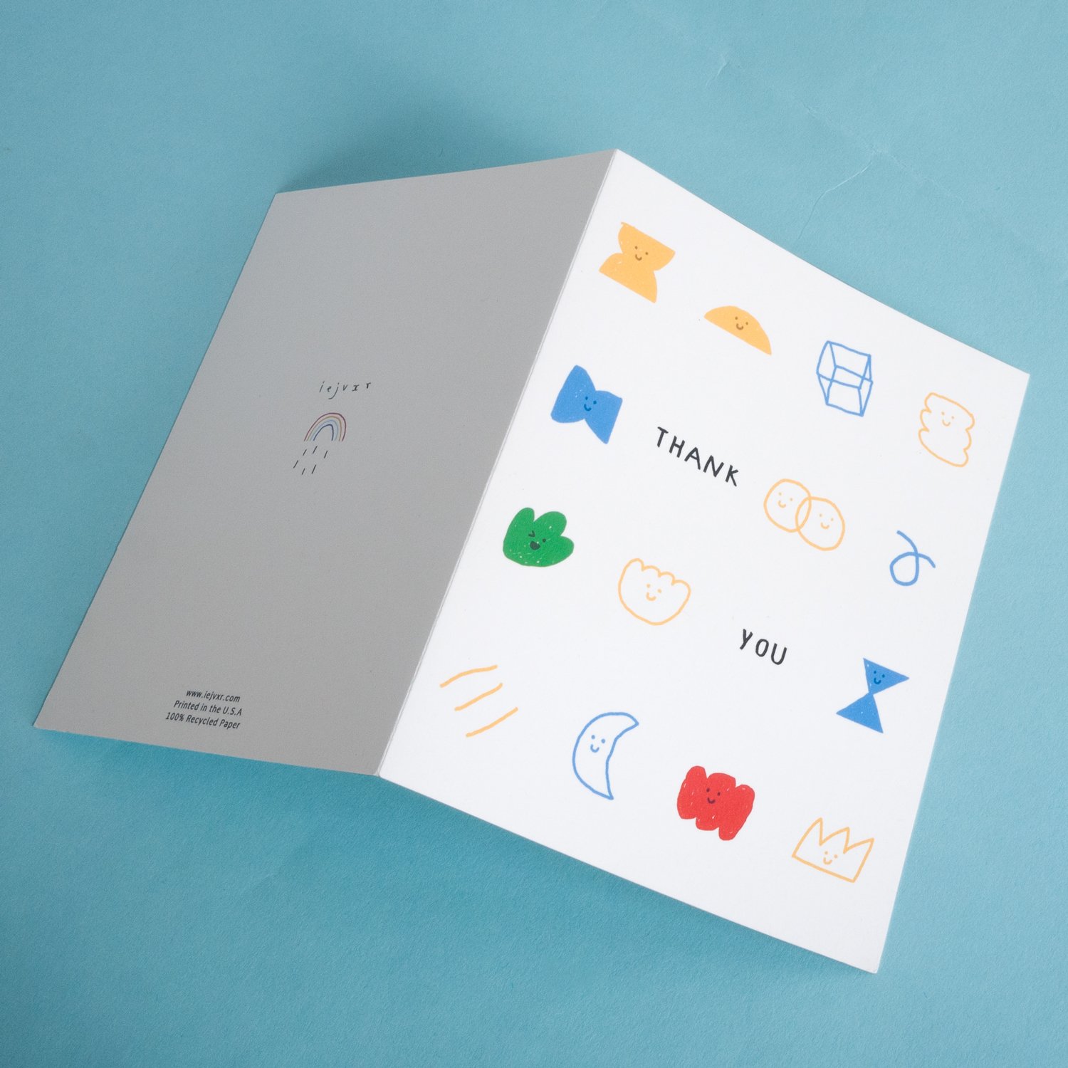 A charming foldable thank you card featuring happy shapes, printed on recycled paper with a Kraft envelope.