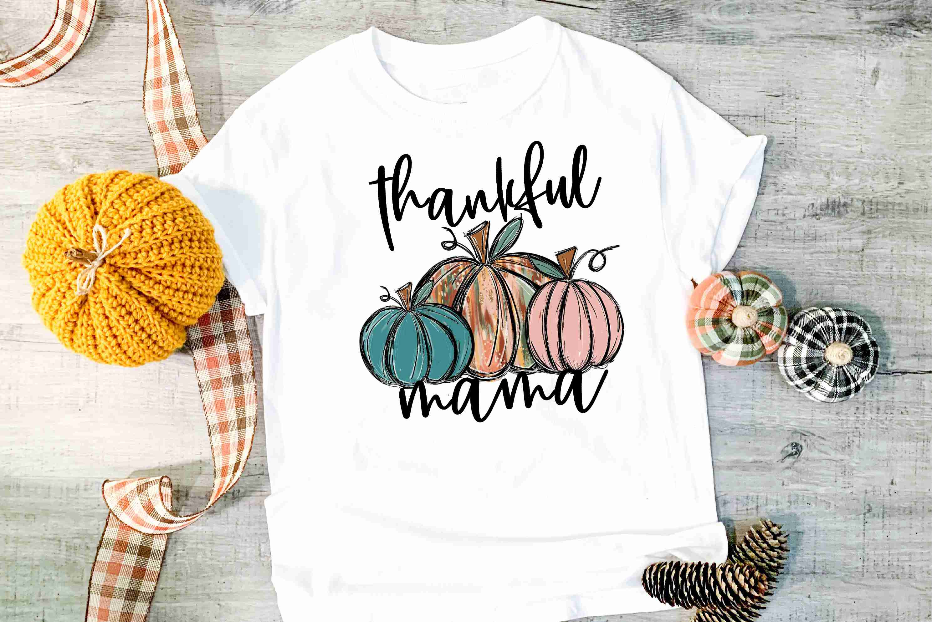 Thankful Mama pumpkins graphic tee on a hanger, showcasing vibrant pumpkin design and soft fabric.