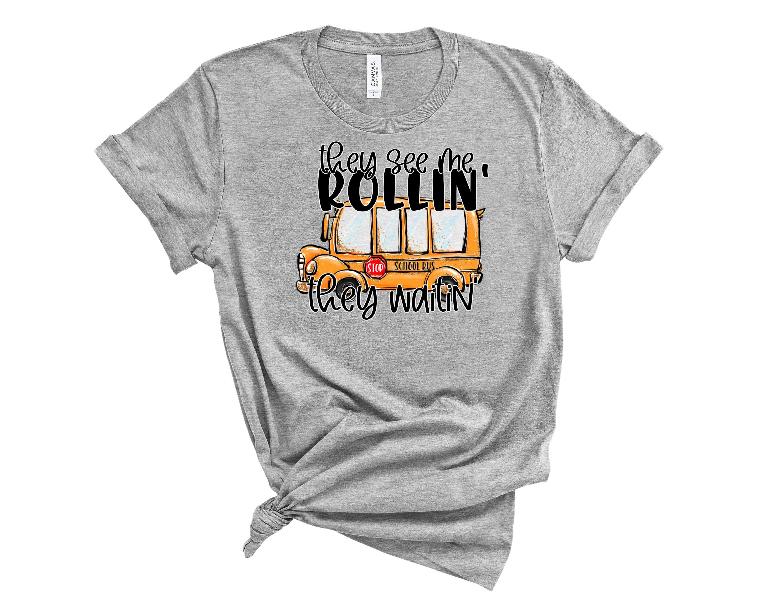 A unisex graphic tee featuring the phrase 'They See Me Rollin' in bold colors, perfect for casual wear.