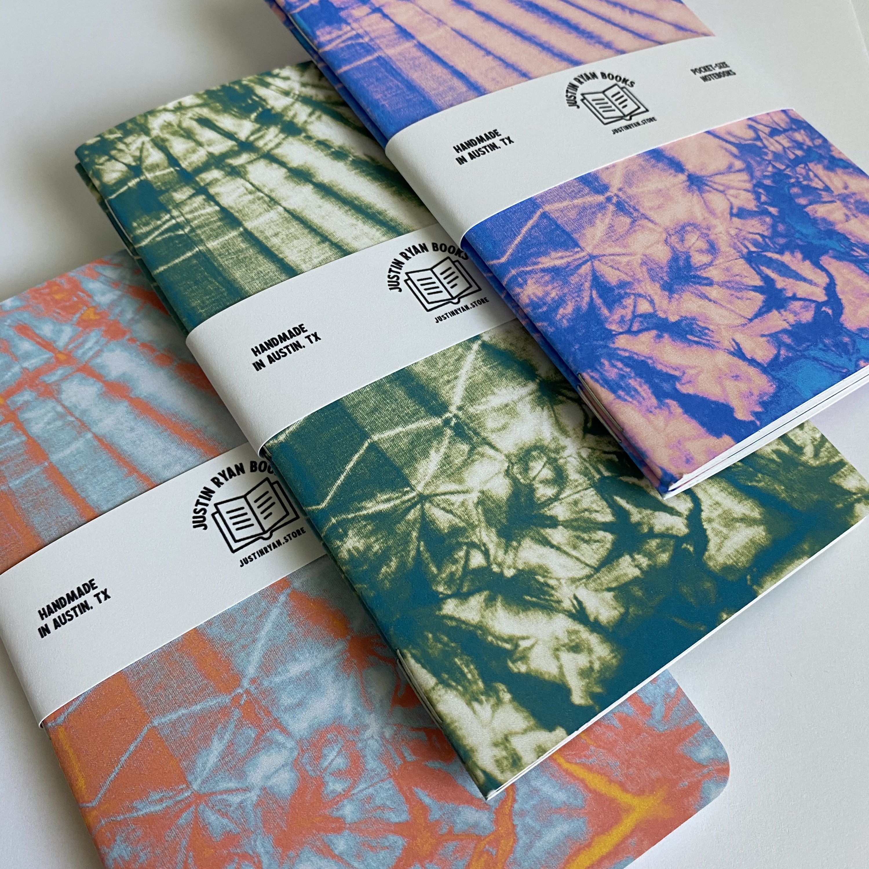Two vibrant Tie Dye notebooks with colorful covers, showcasing various color options and inner paper styles.