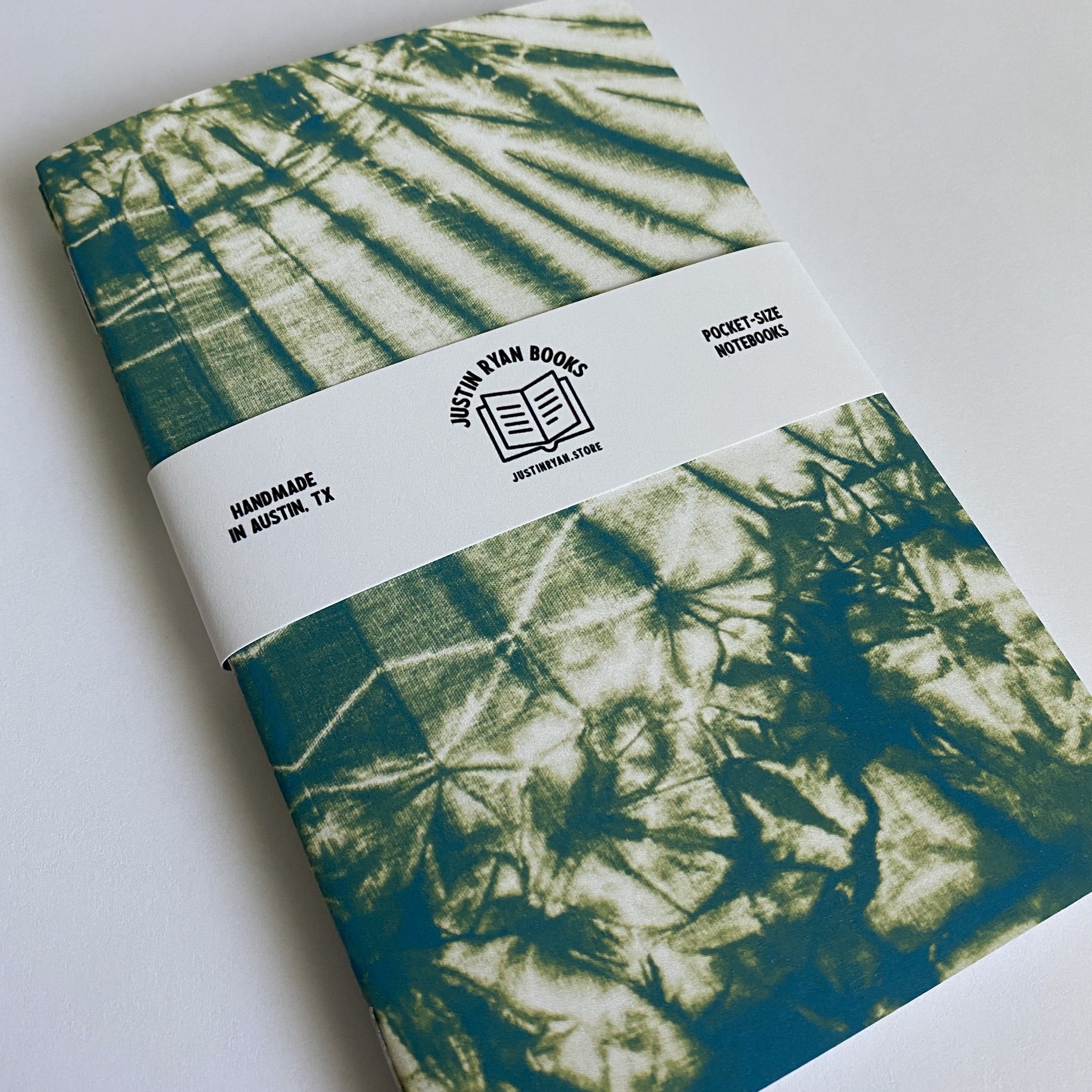 Two vibrant Tie Dye notebooks with colorful covers, showcasing various color options and inner paper styles.