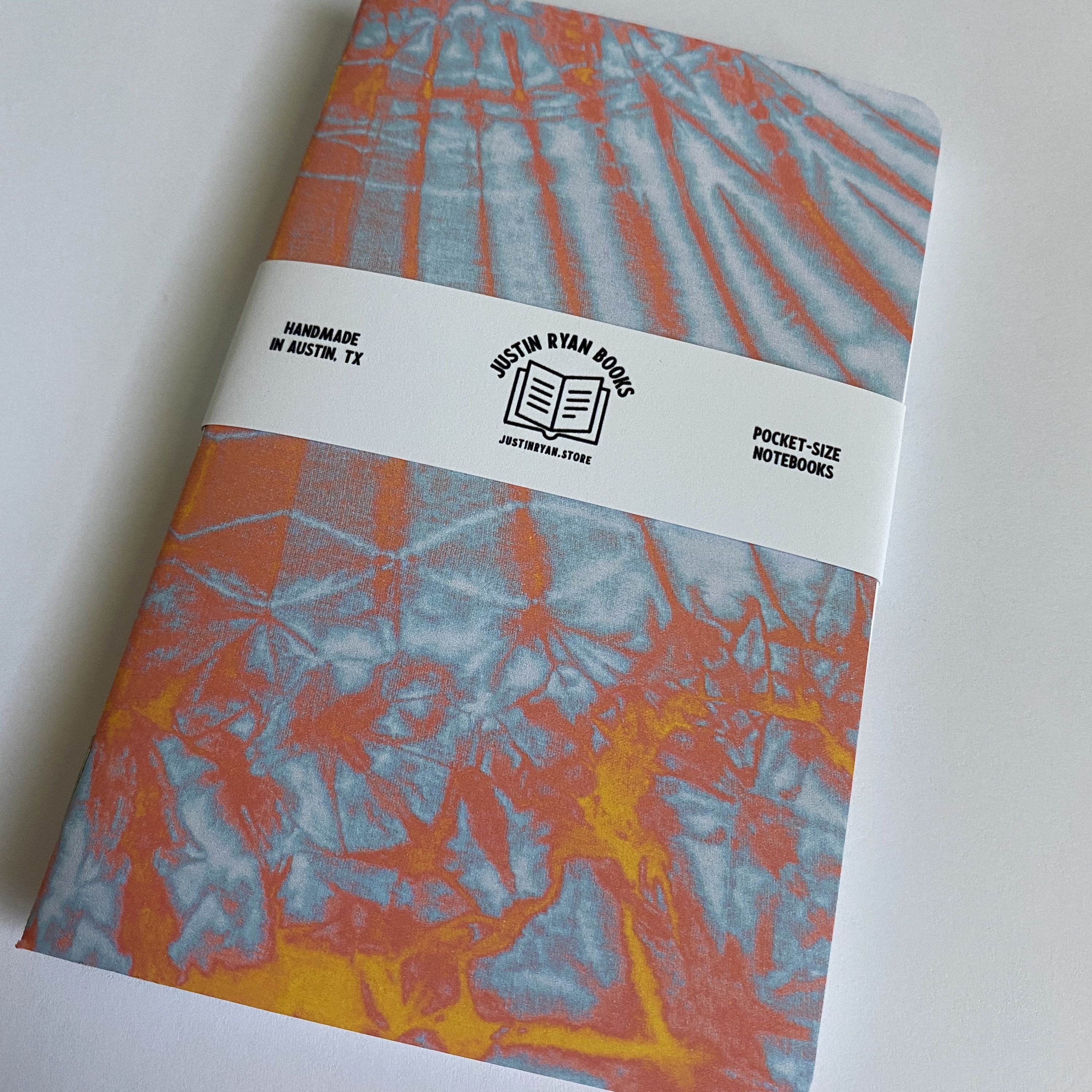 Two vibrant Tie Dye notebooks with colorful covers, showcasing various color options and inner paper styles.