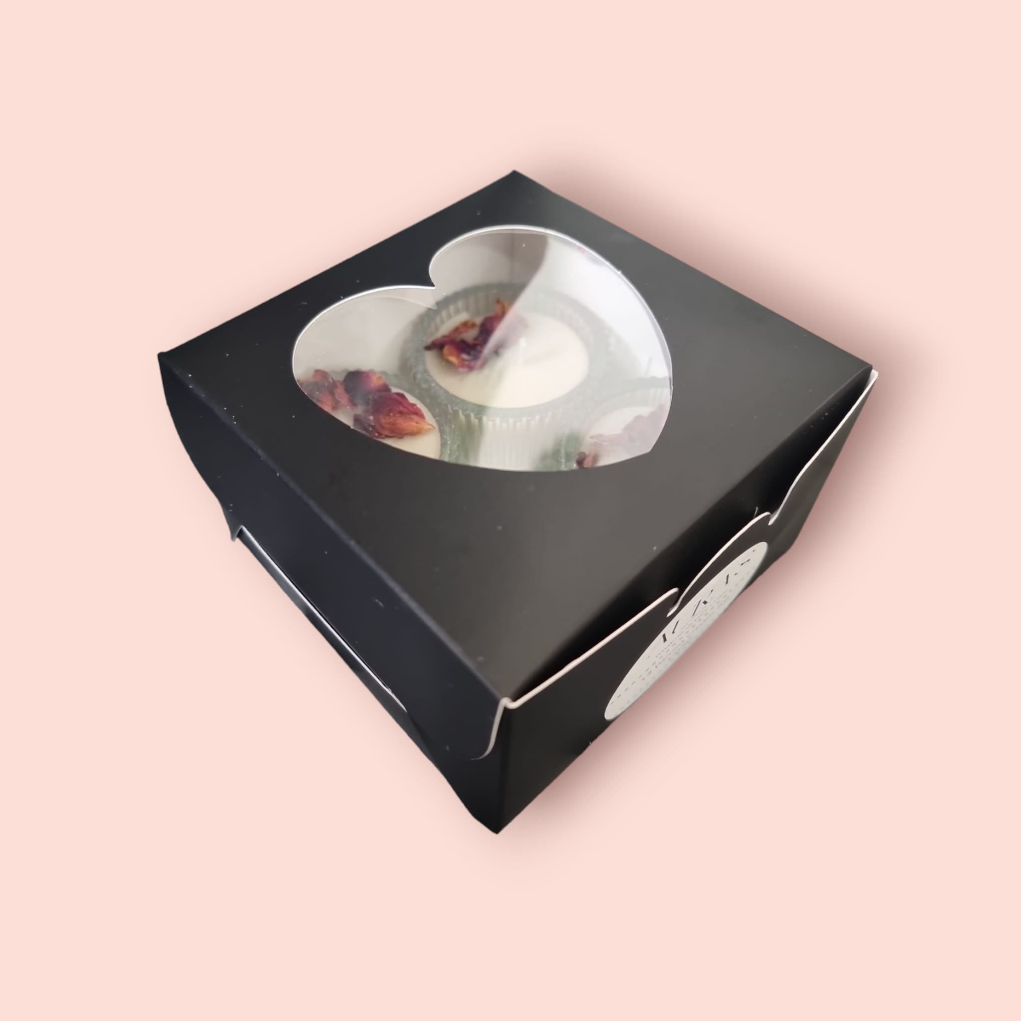 A beautifully arranged Valentine's Gift Set featuring four heart-shaped tealights in vanilla cream scent, elegantly packaged in a sleek black box.